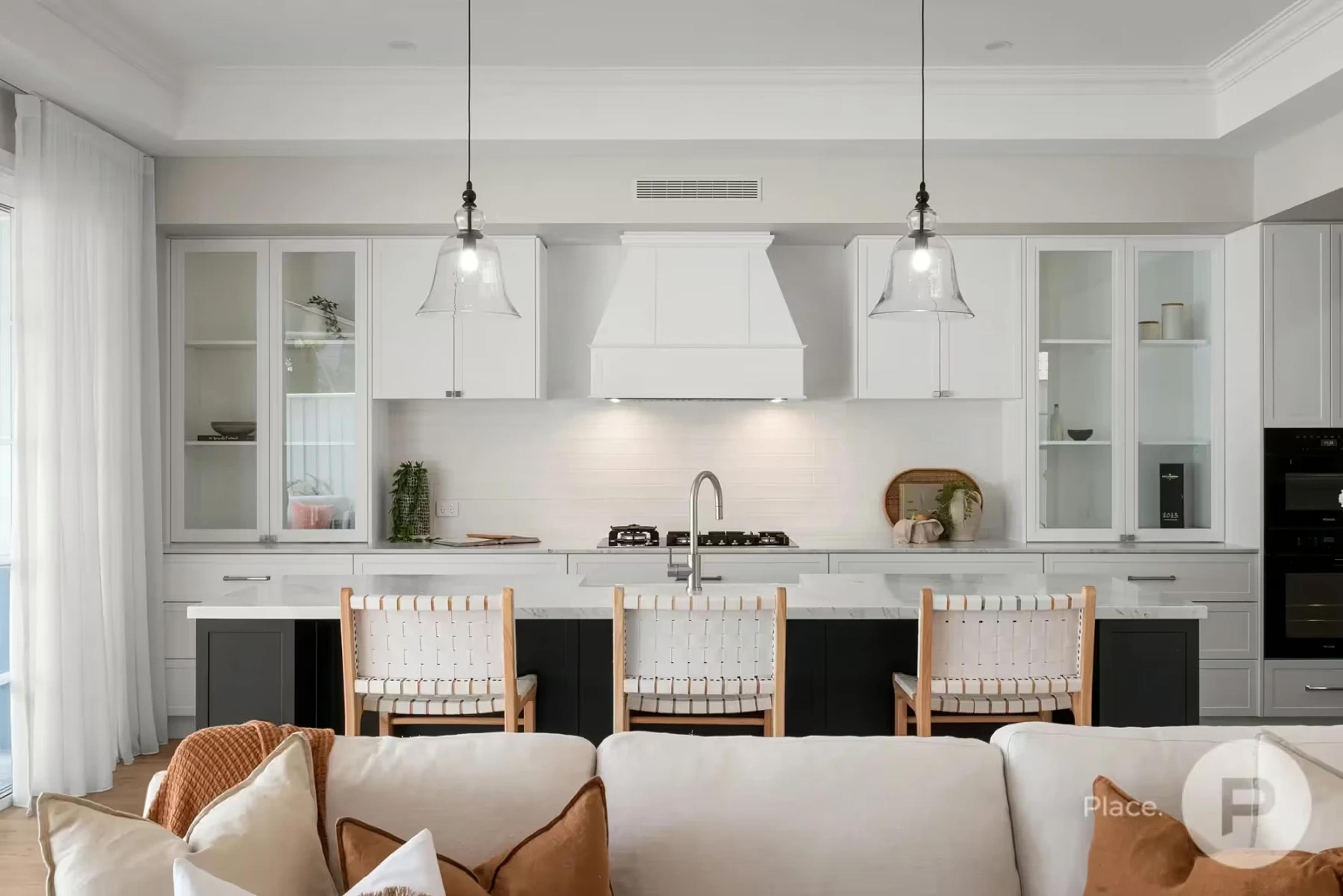 White kitchen with island bench and pendant lights
