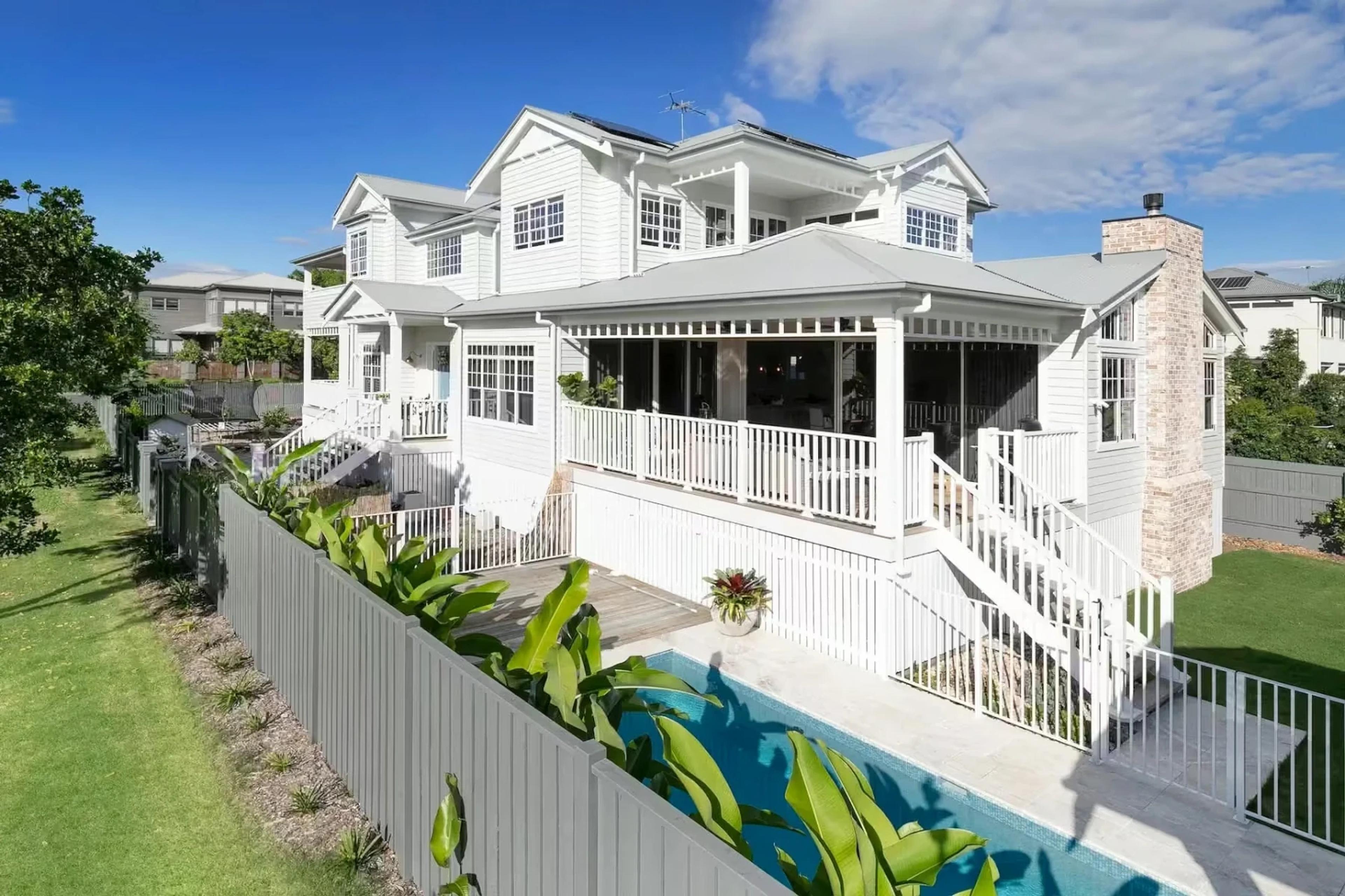 White weatherboard Hamptons style home with verandah and pool