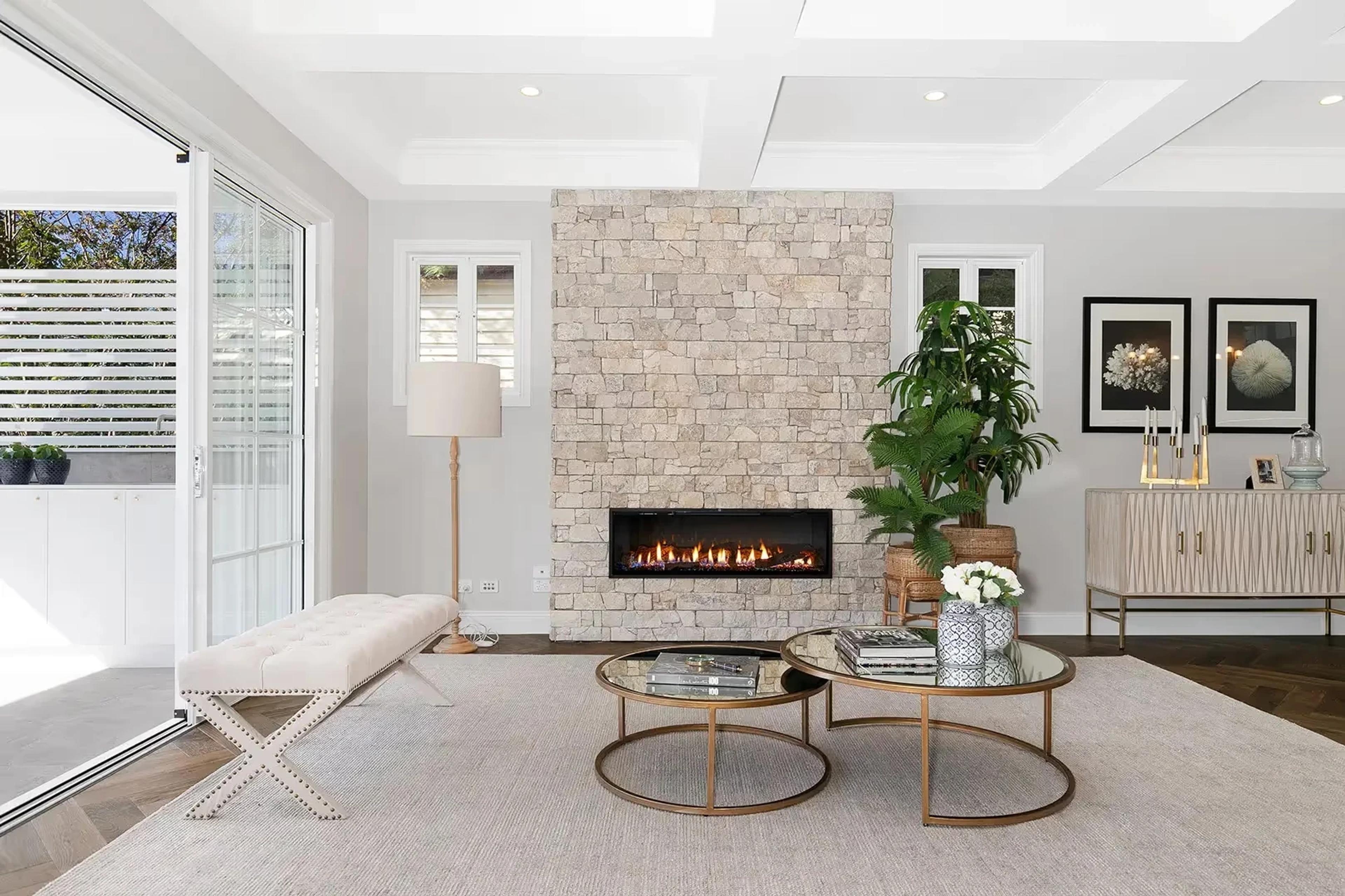 Living room with stone gas fireplace and glass coffee tables