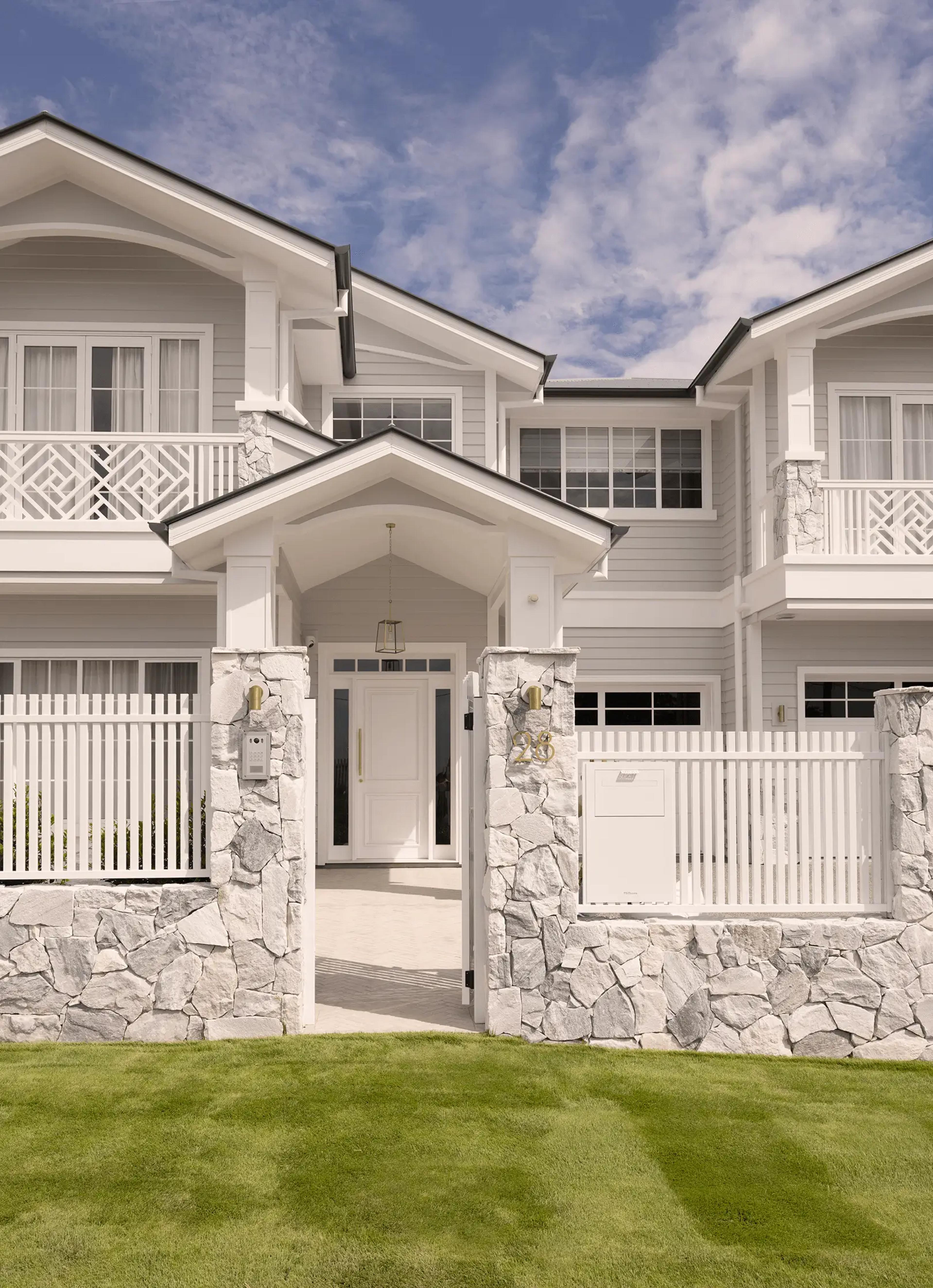 Front entry with gabled portico and stone gate piers