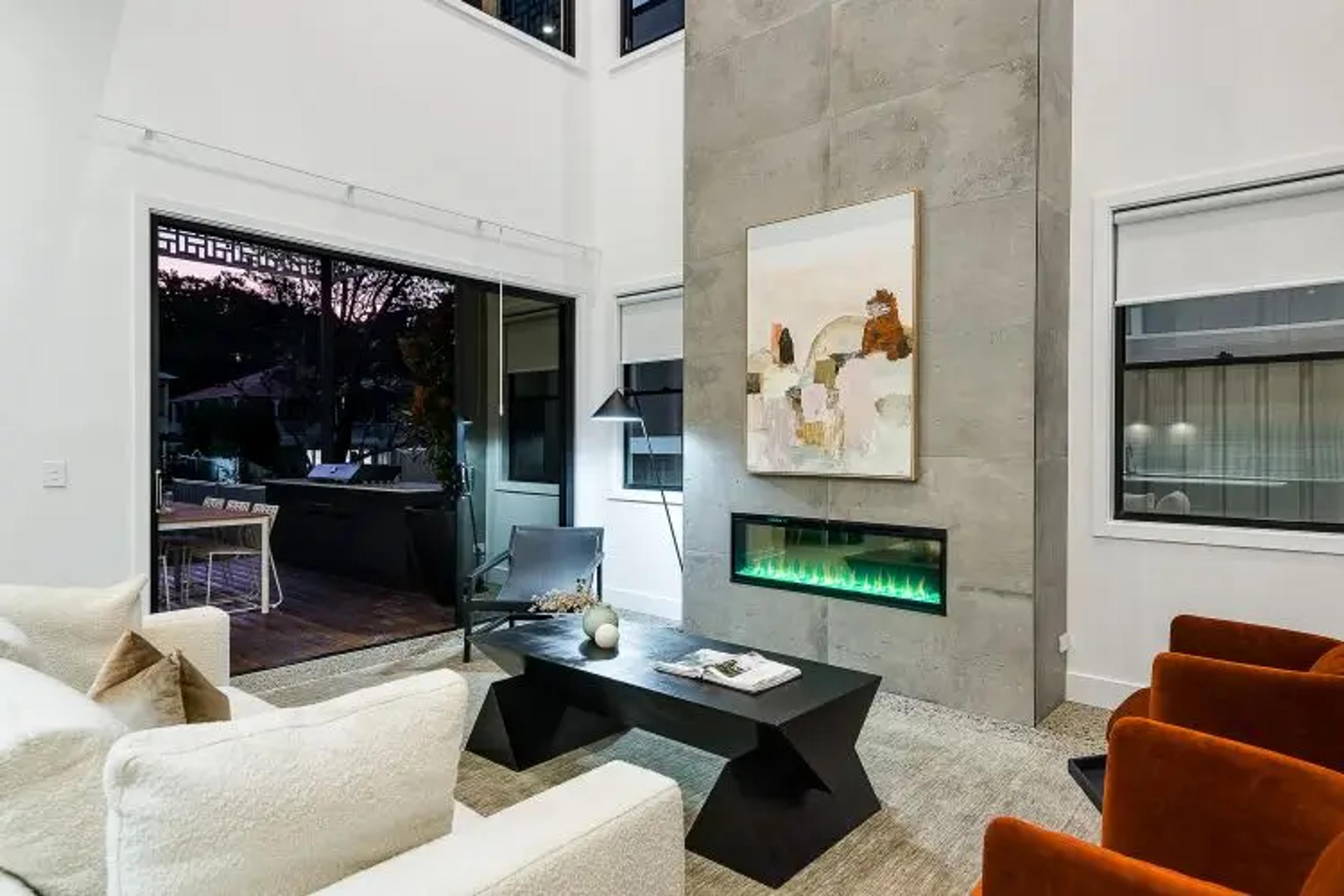 Living room with linear fireplace and concrete feature wall