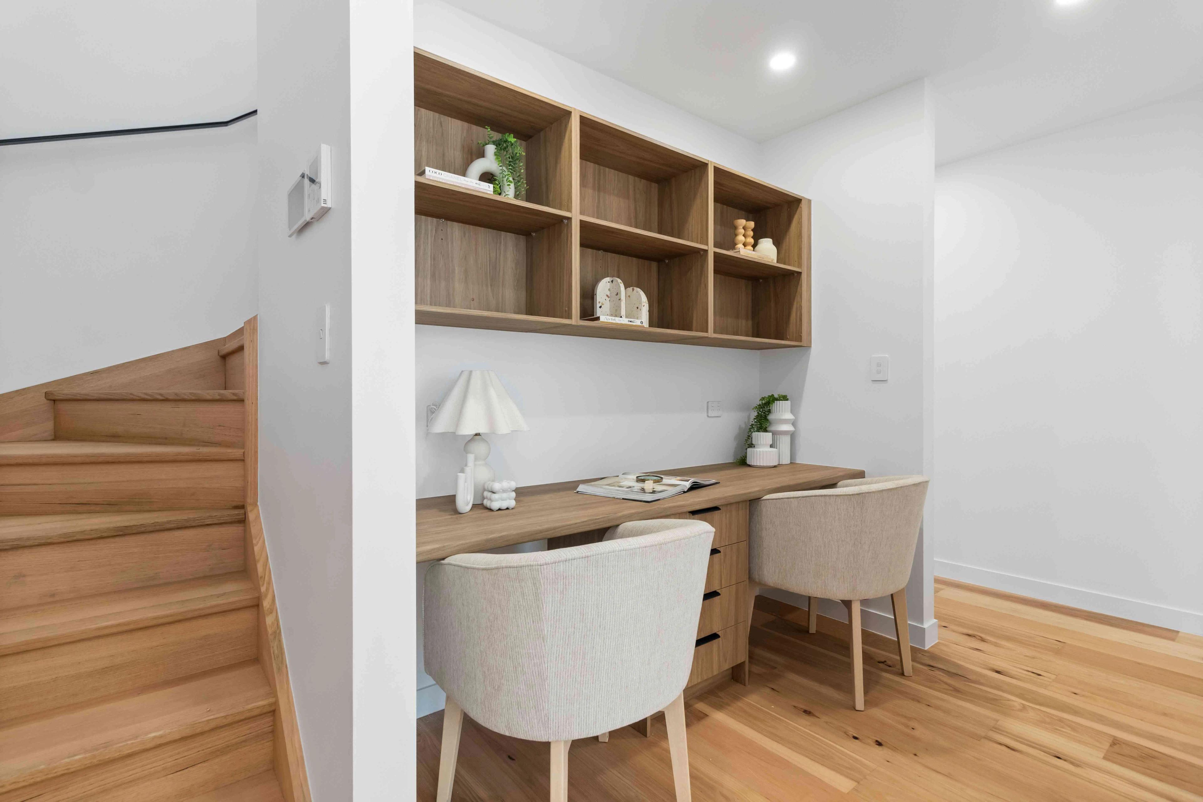 Study nook with timber desk, shelving and stairs alongside
