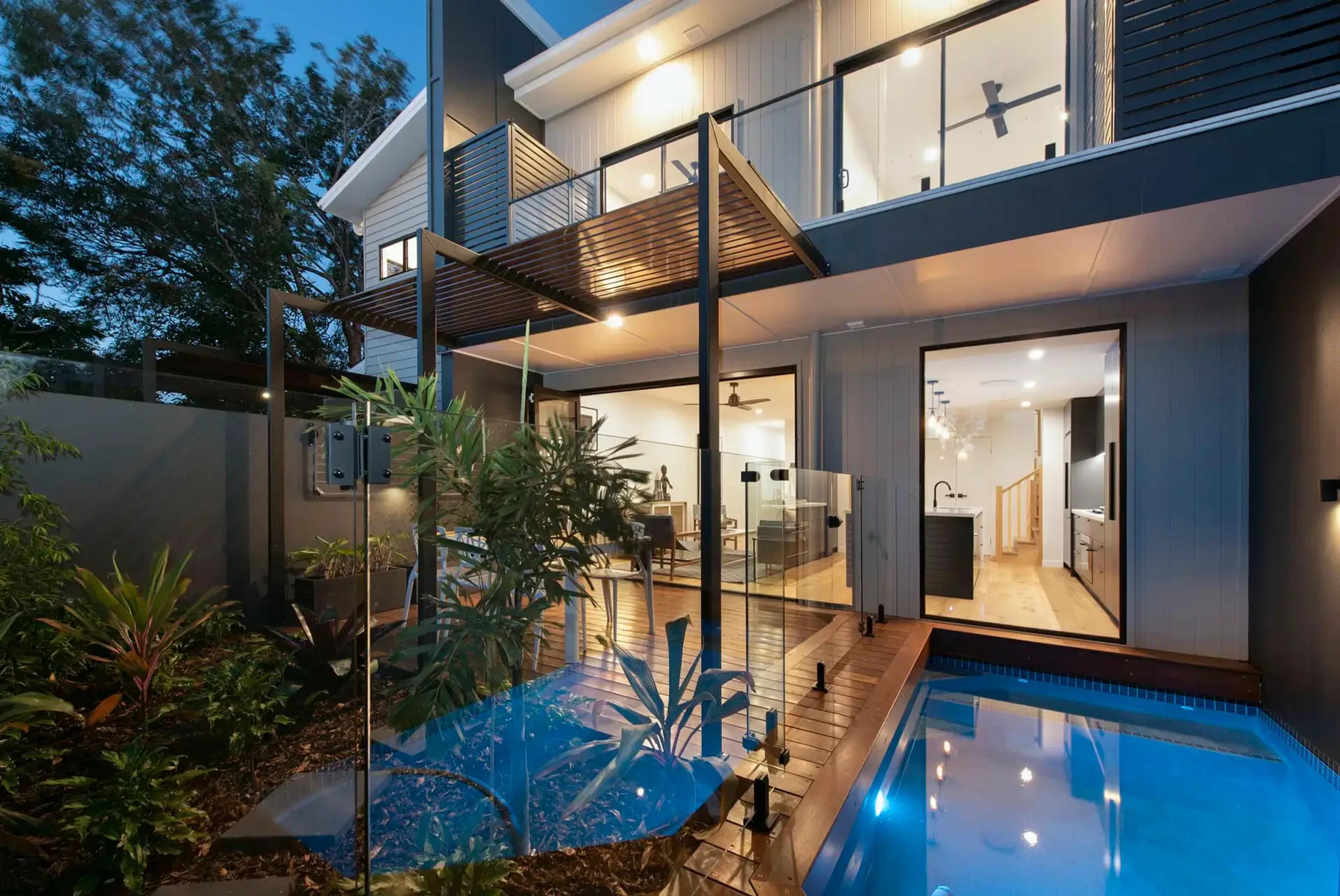 Contemporary townhouse rear exterior with courtyard pool at dusk