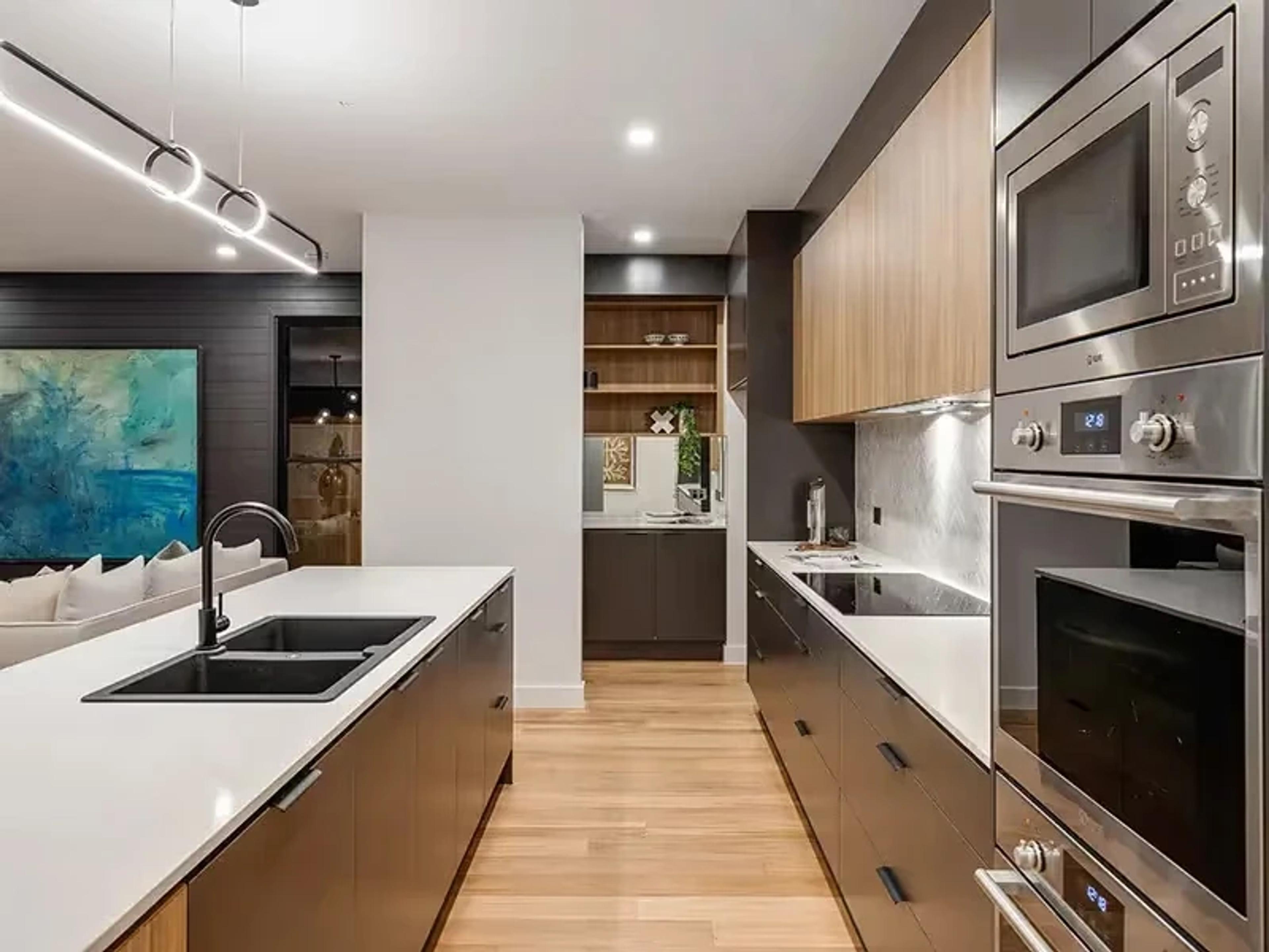 Galley kitchen with double sink and stainless steel appliances