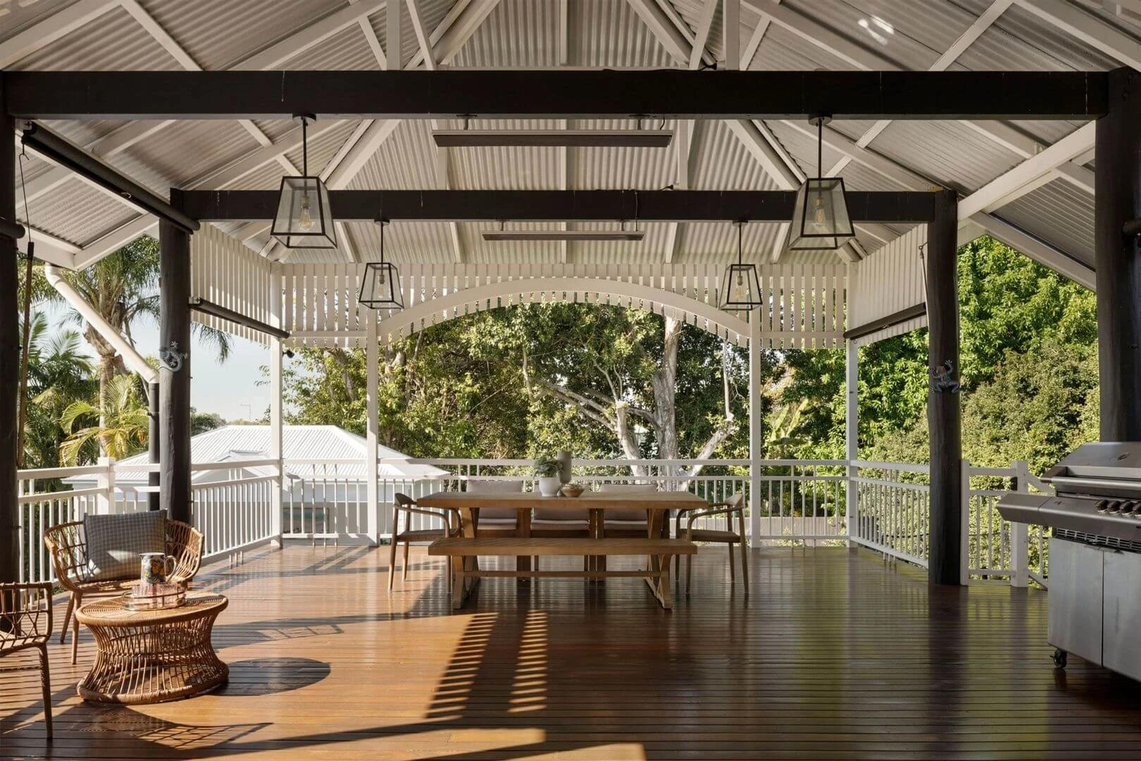 Covered timber deck with dining table, barbecue and treetop views