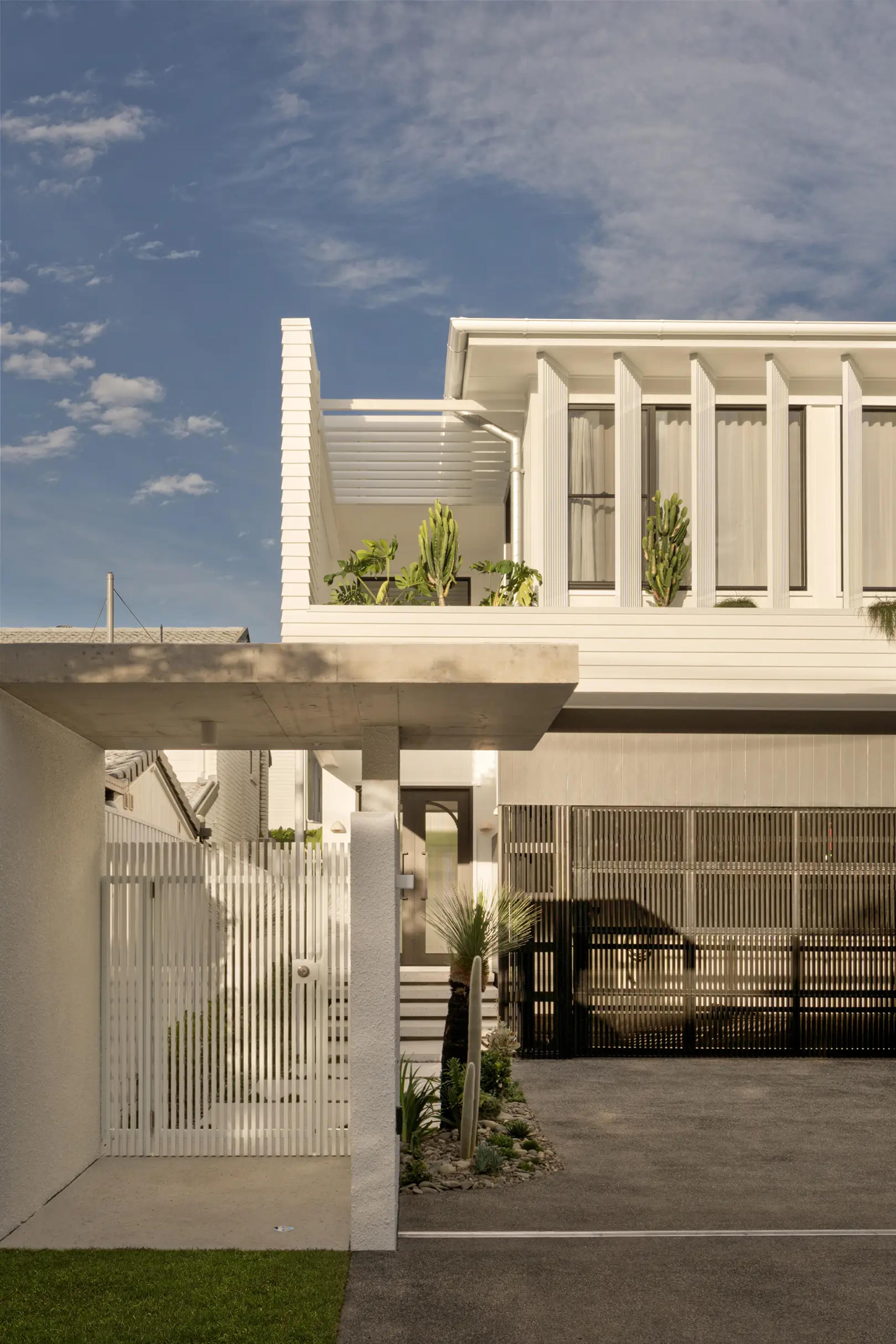 Close view of white home front entry, gate and garage