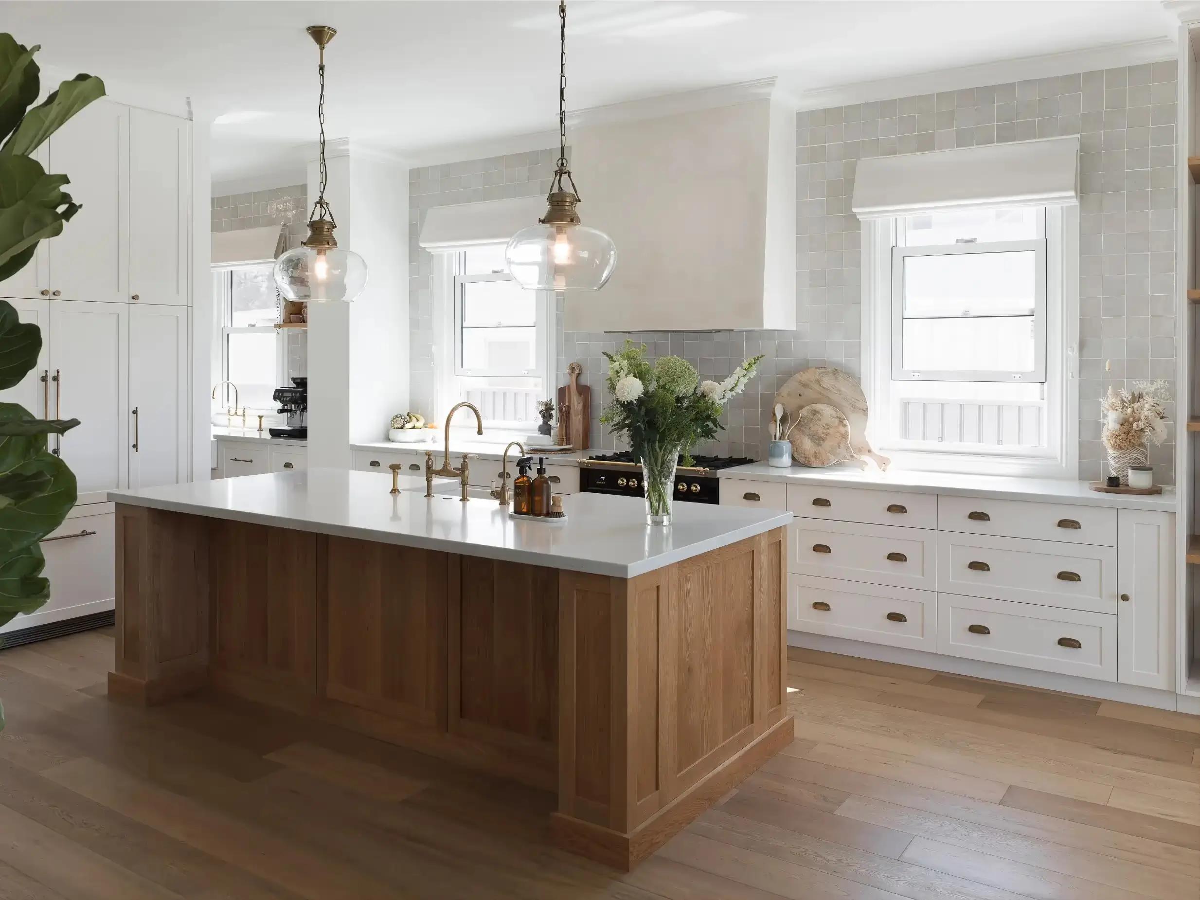 A timber and neutral palette kitchen with 2 glass pendants over the island bench