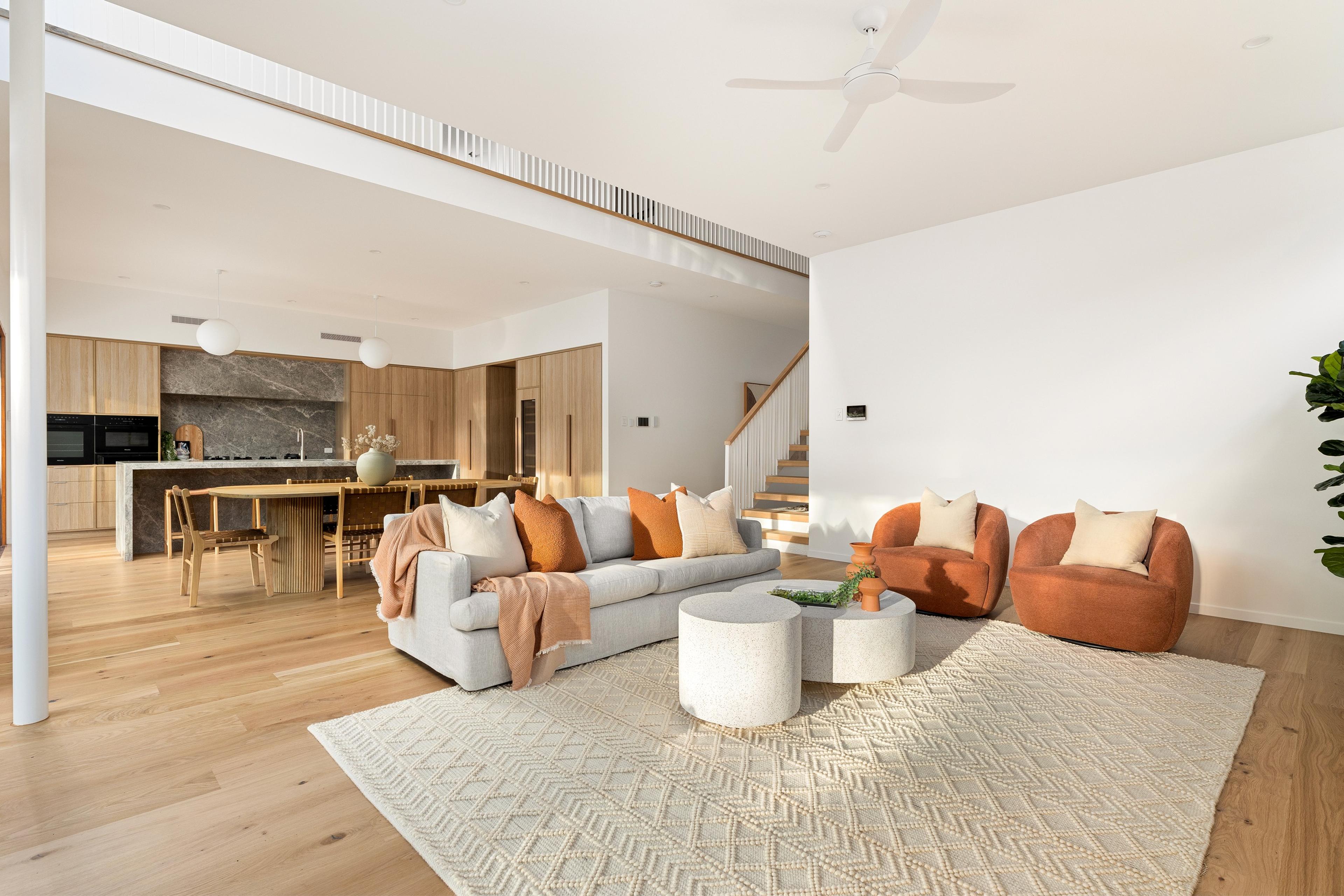 Living room with sofa, armchairs and open kitchen beyond