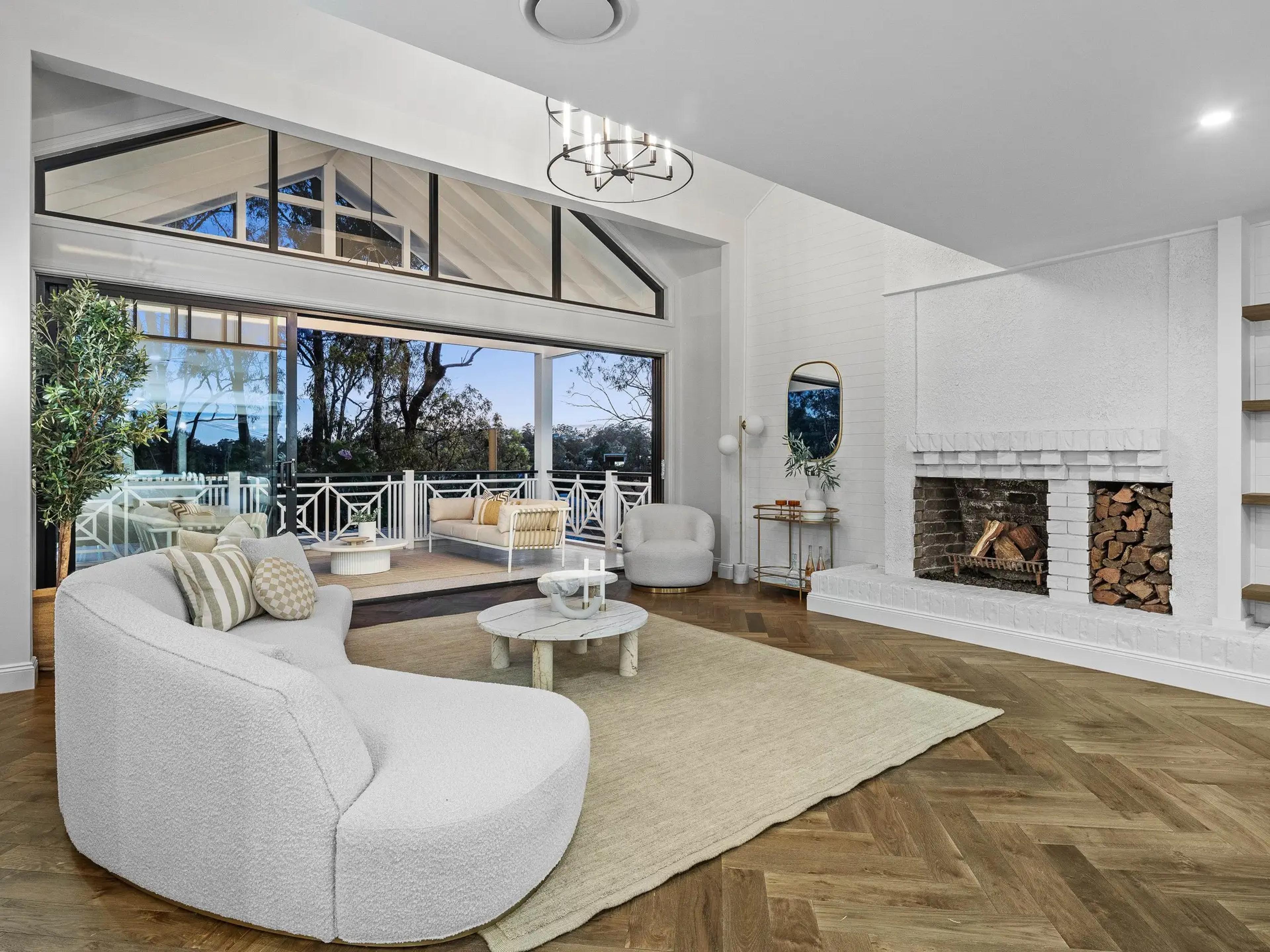 Living room with white brick fireplace and covered deck