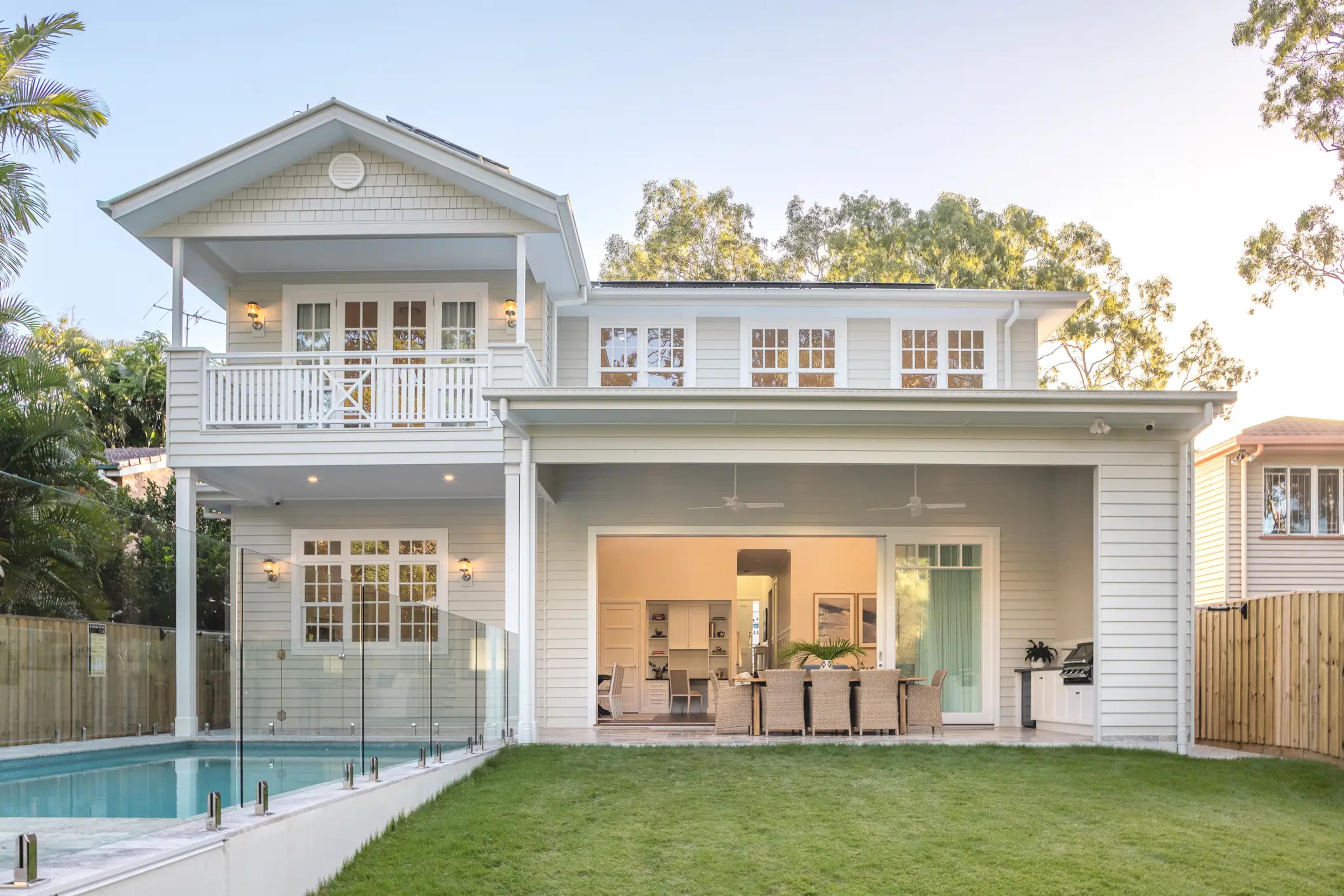 Rear elevation of white weatherboard home with pool, balcony and alfresco
