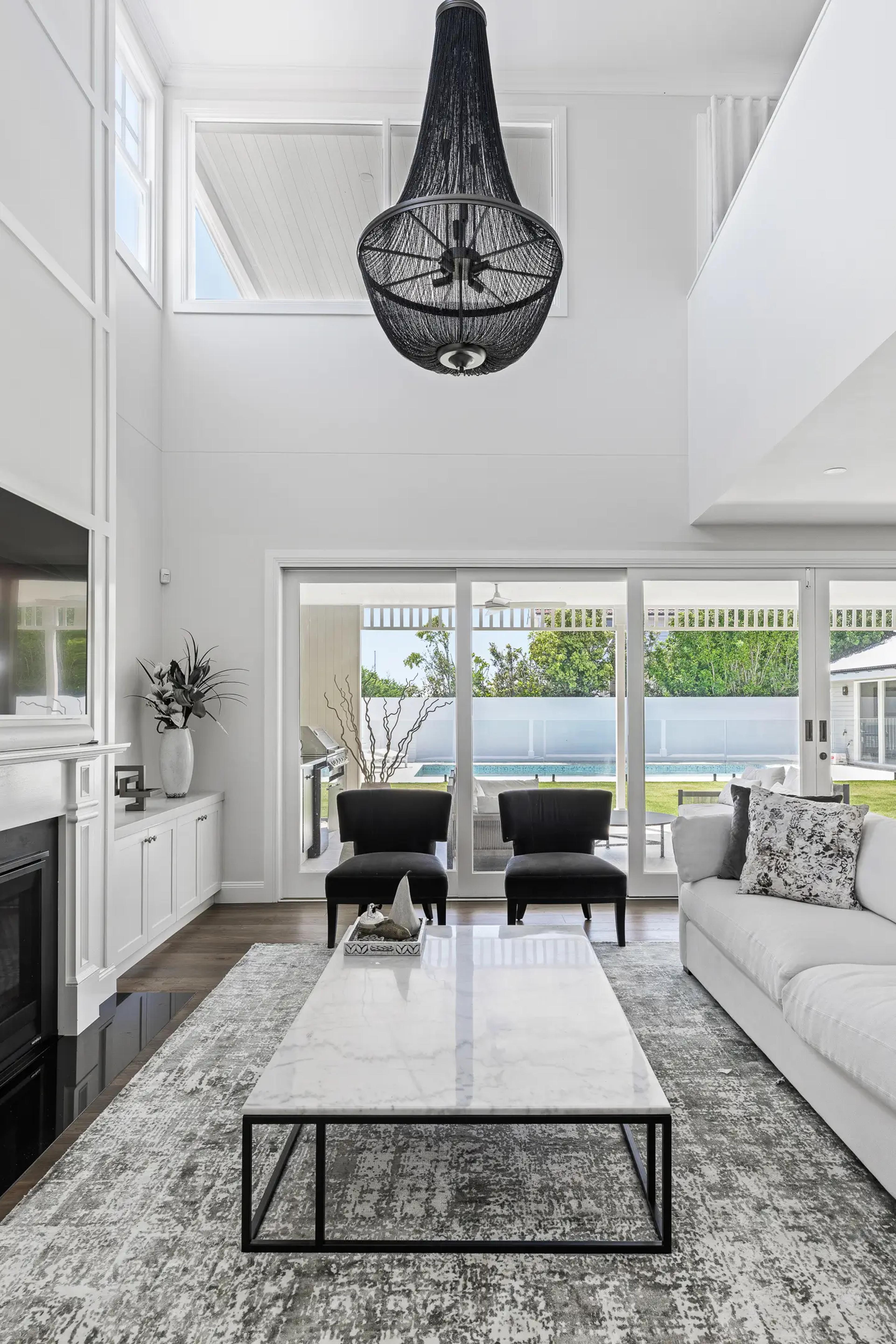 Double height living room opening to poolside garden
