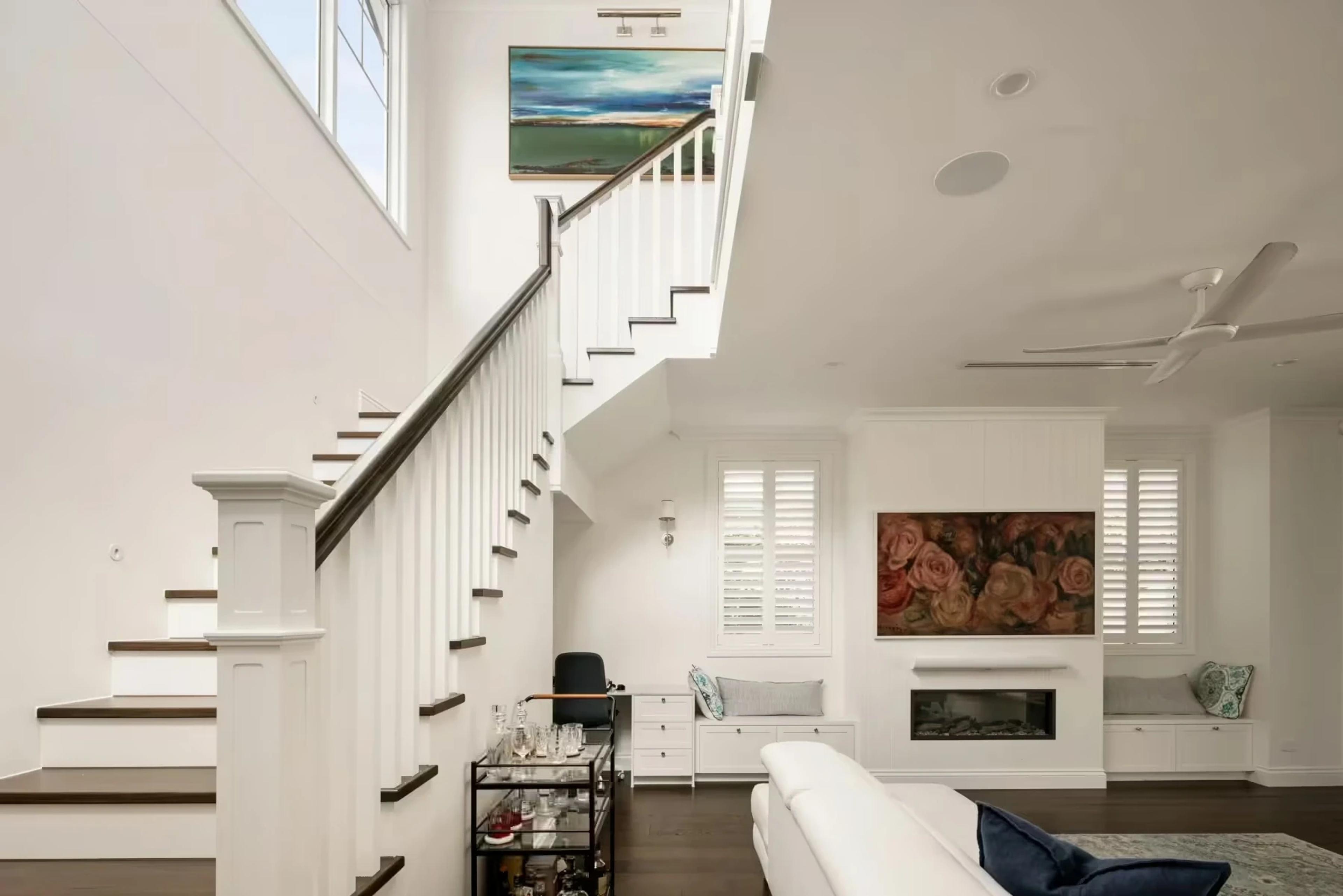 Timber staircase with void beside living room and fireplace
