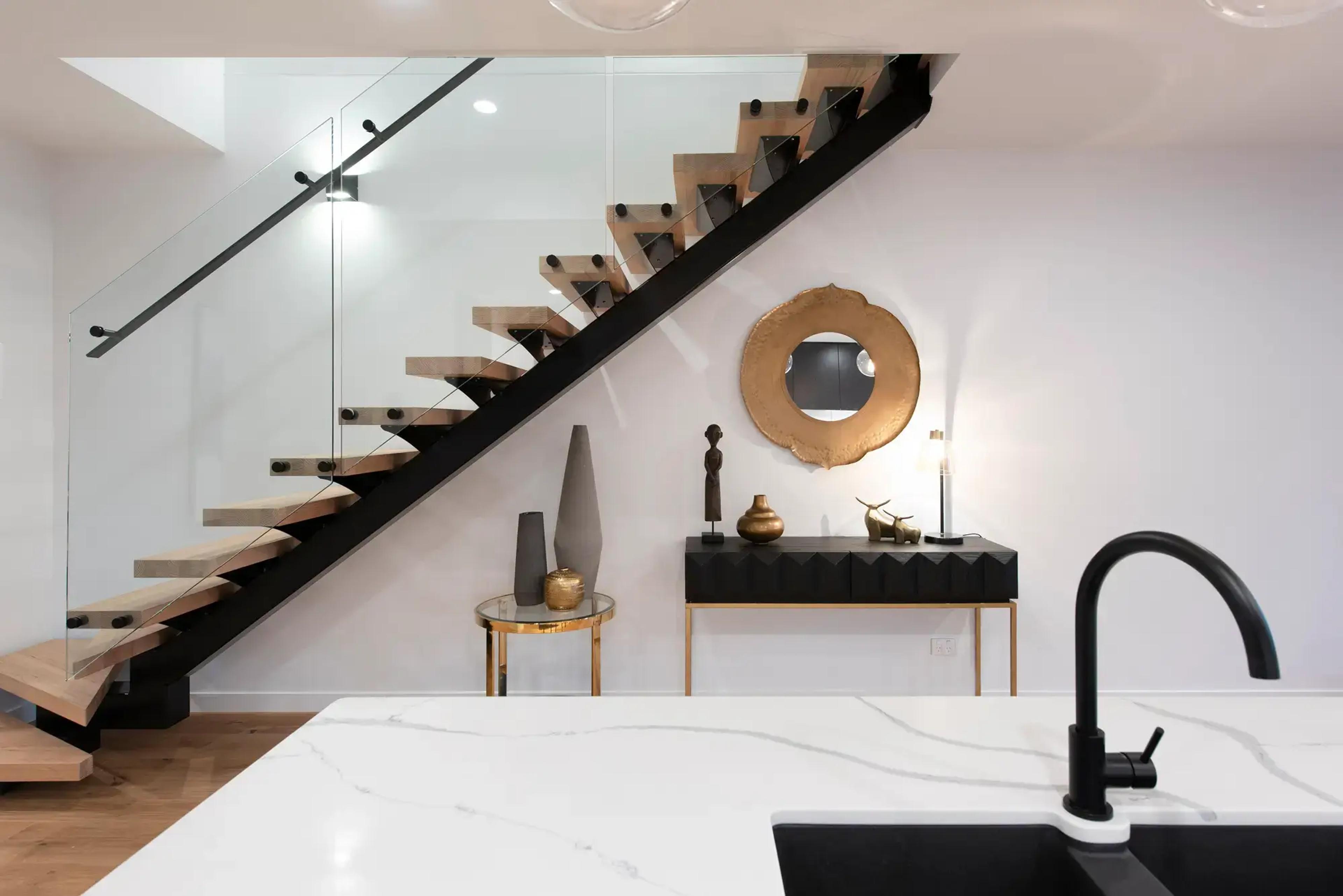 Floating timber staircase with glass balustrade and console table