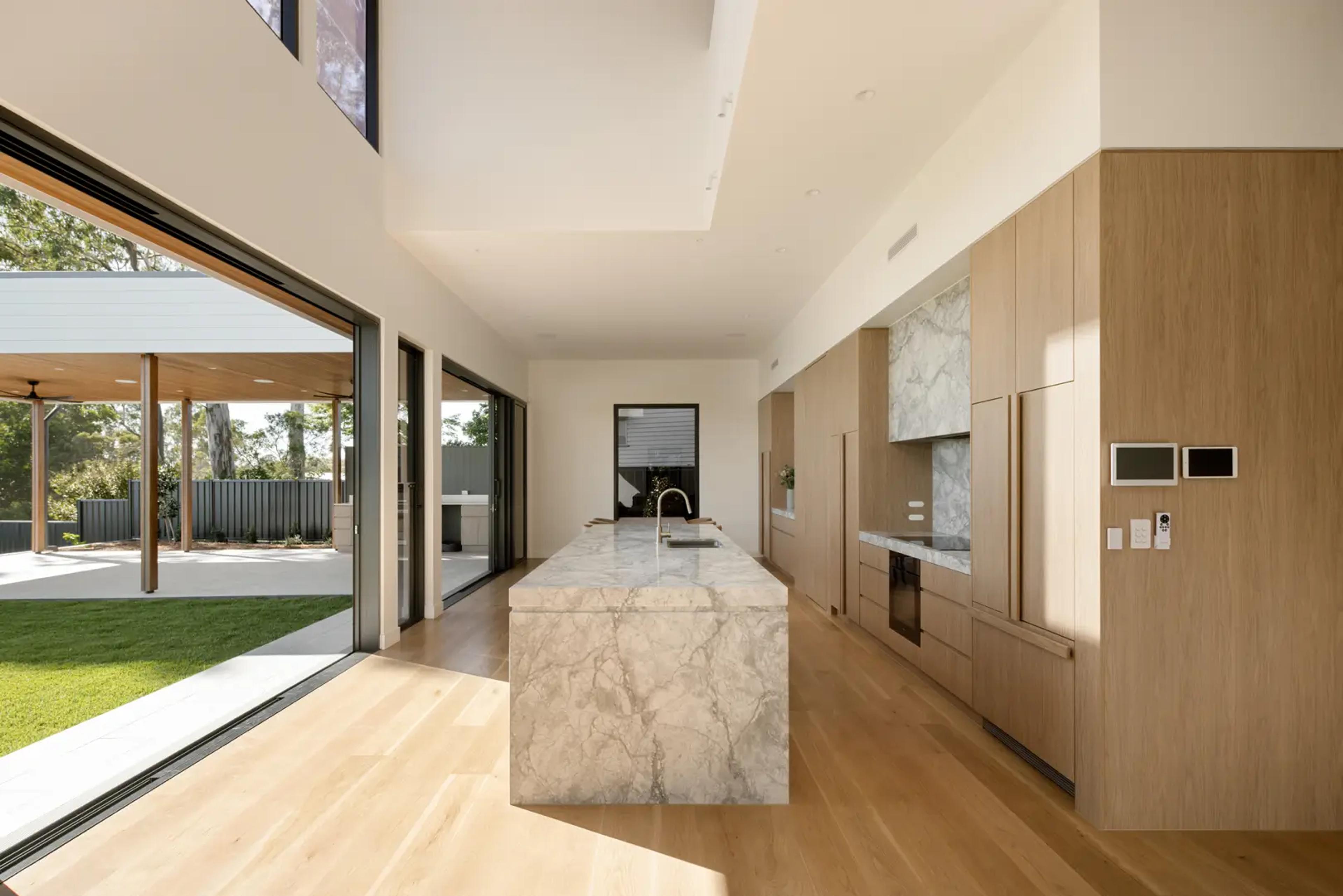 Open kitchen with marble island and sliding doors to garden