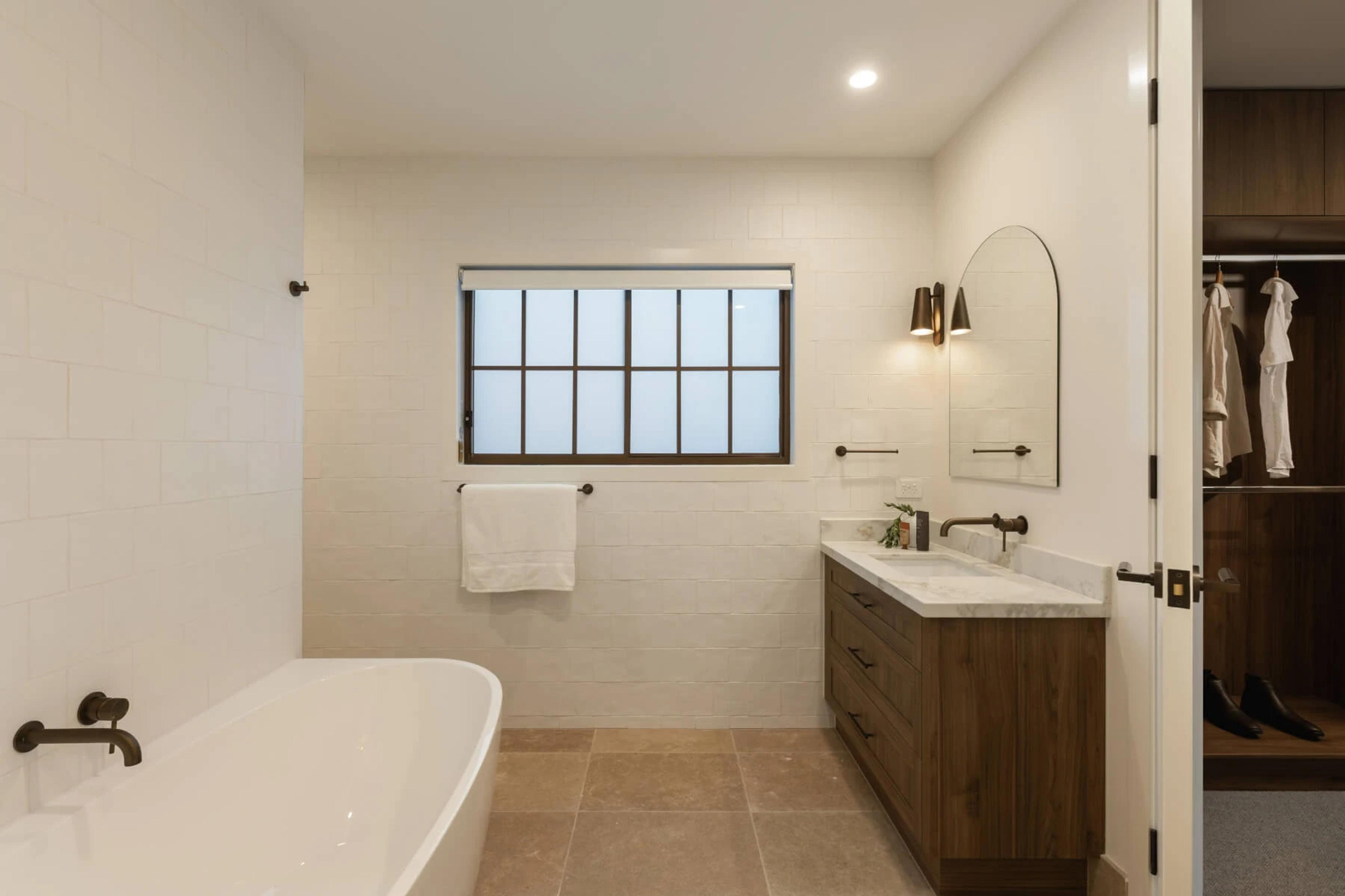 Bathroom with freestanding bath, timber vanity and adjoining wardrobe
