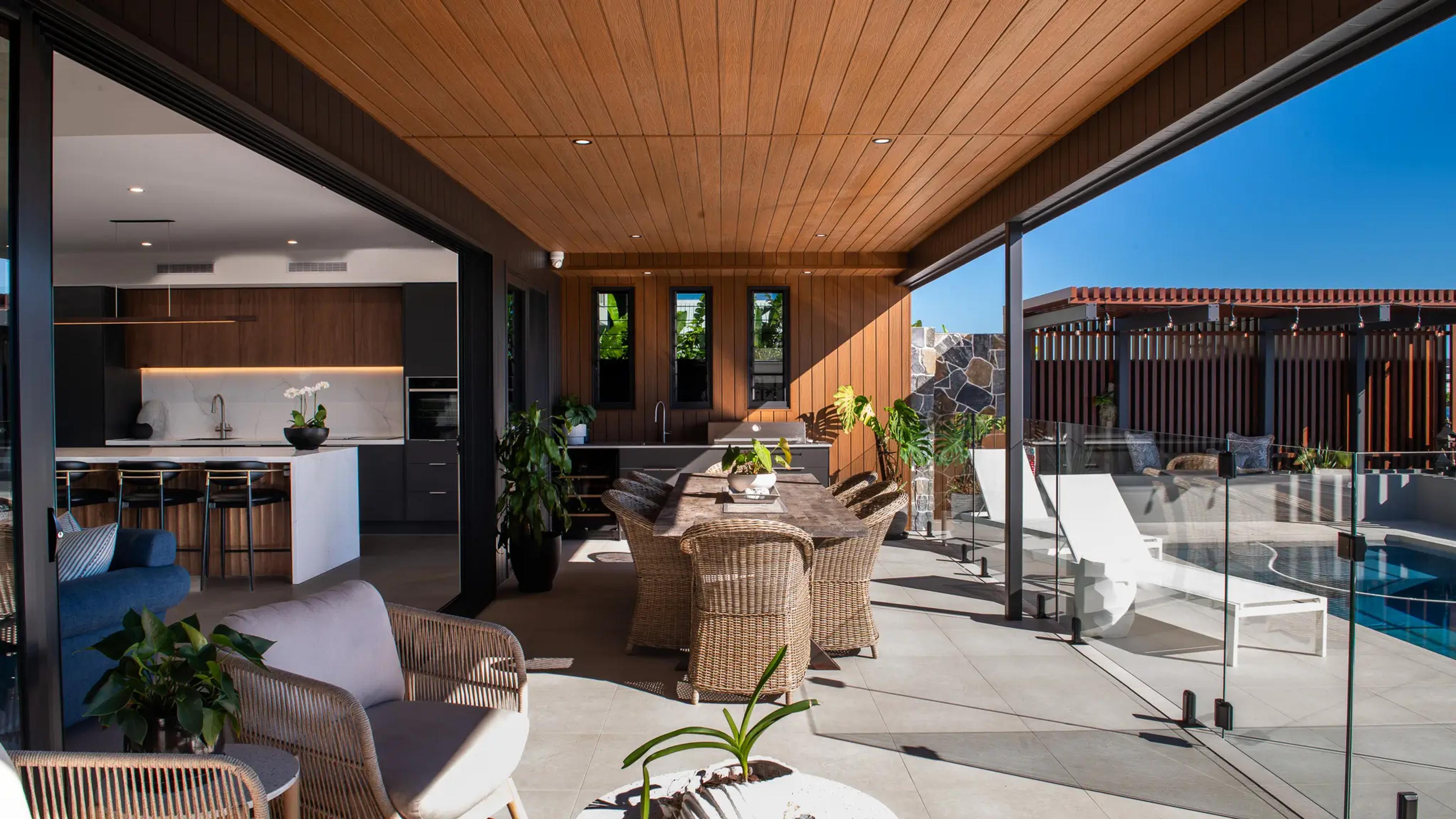 Covered outdoor terrace beside glass fenced pool