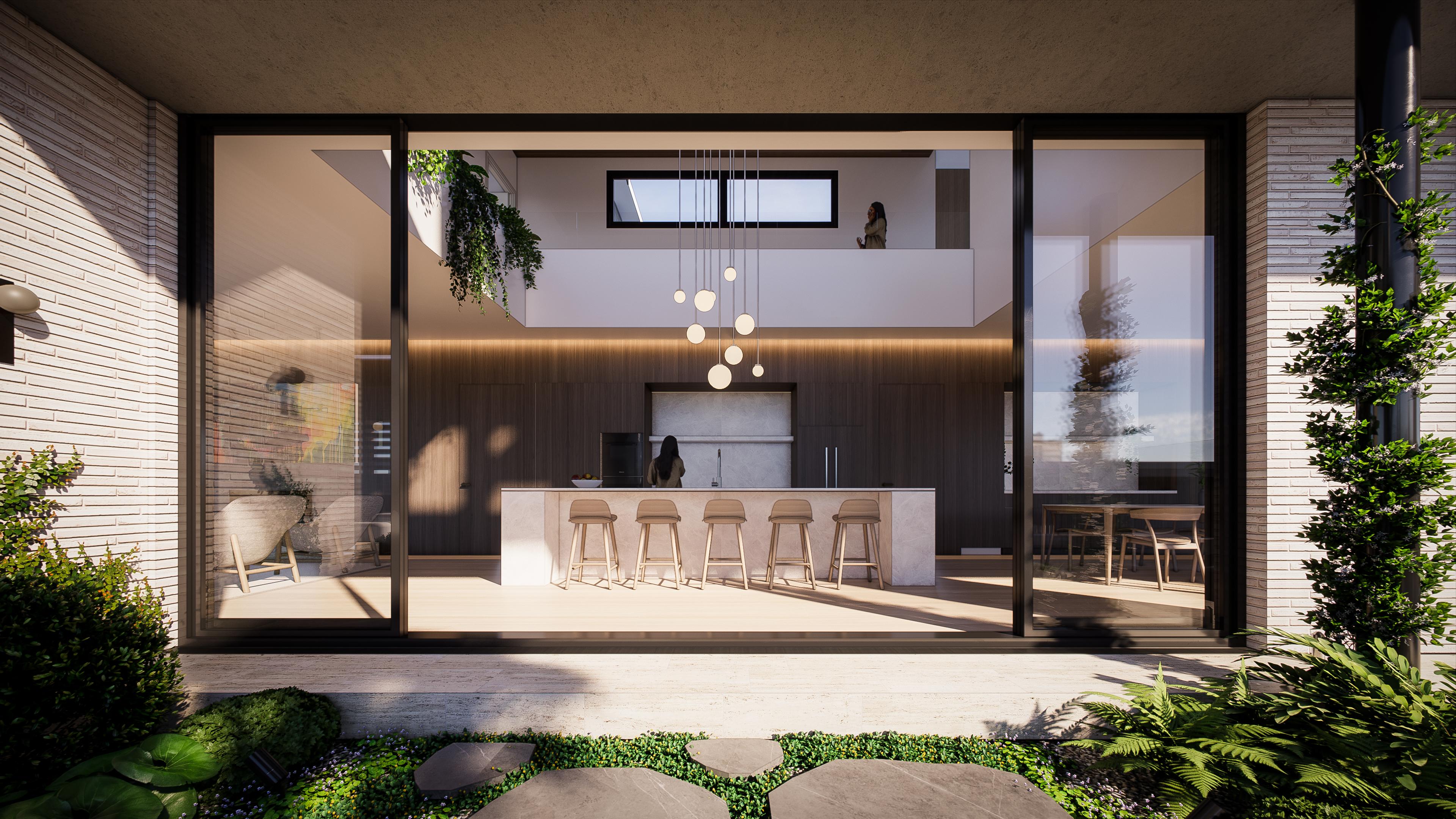 Kitchen and island viewed from the courtyard through full height glass, with pendant lights dropping into a tall void