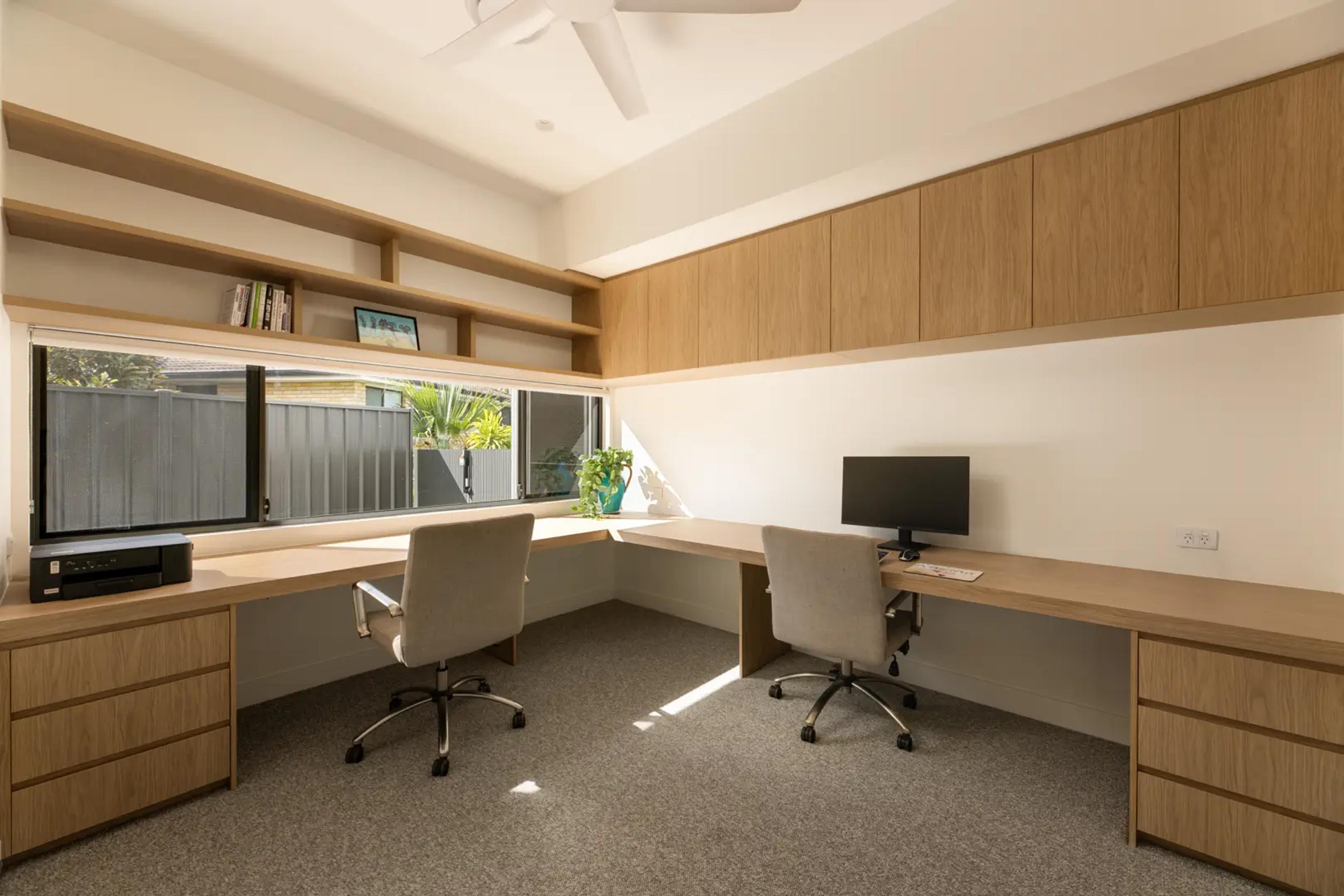 Home office with twin desks and built in shelving