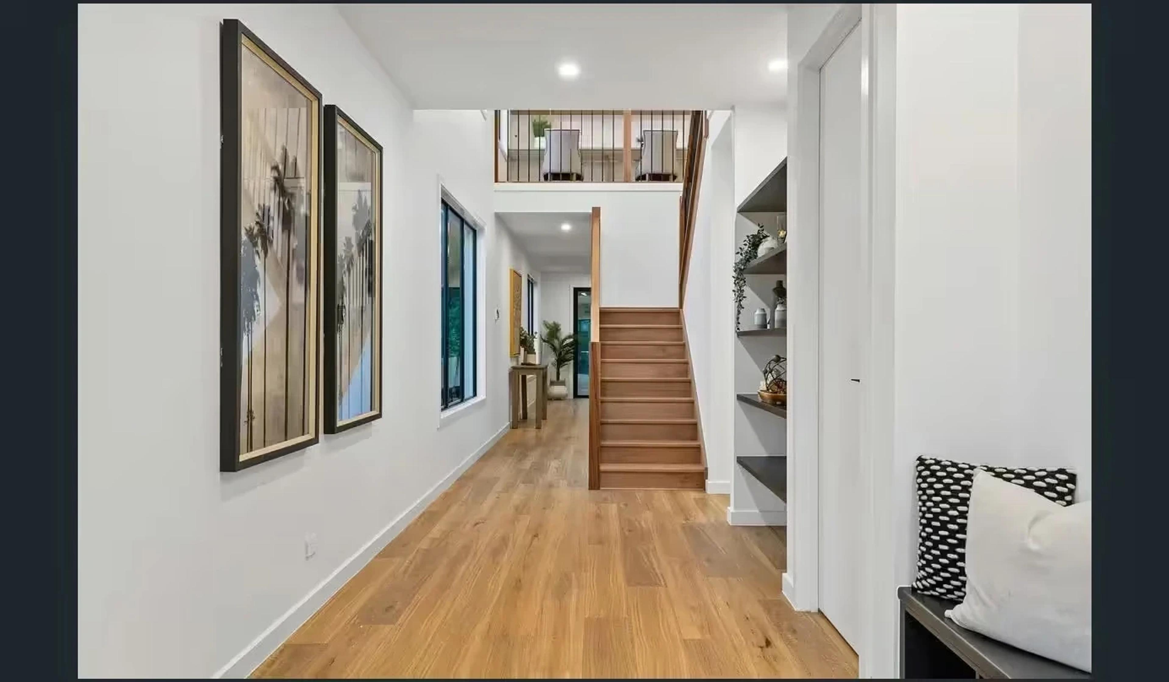 Entry hallway with timber floors and staircase to upper level