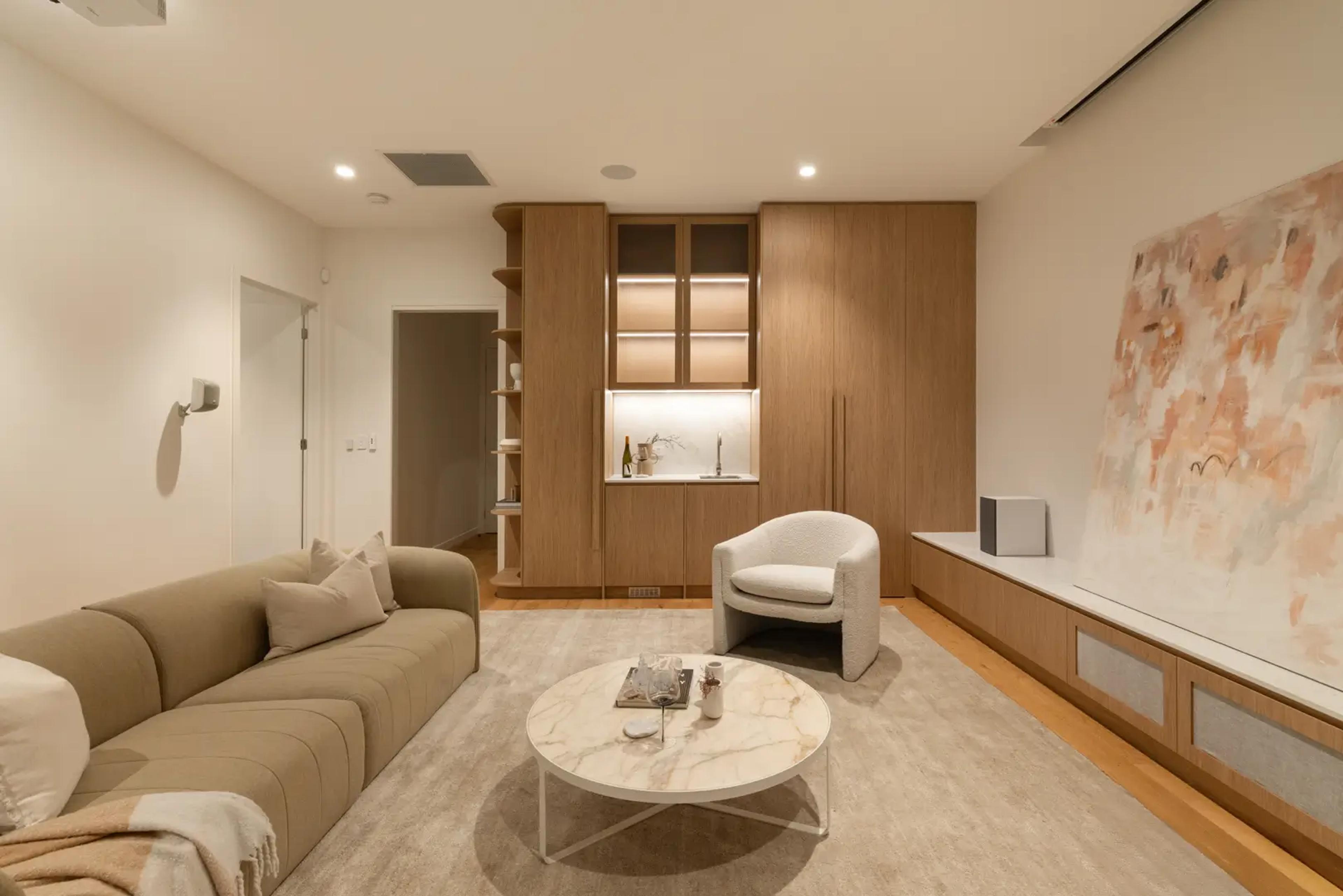 Sitting room with sofa, kitchenette and artwork