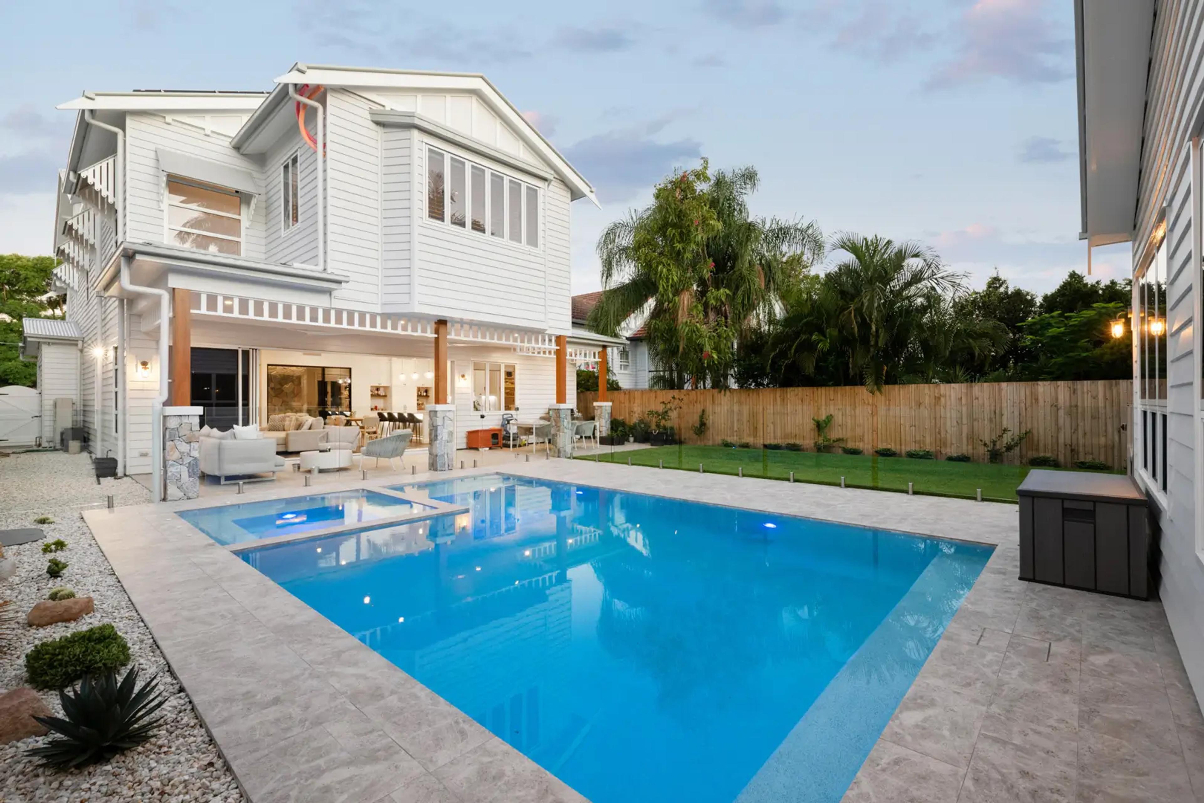 Rear of white weatherboard home with swimming pool