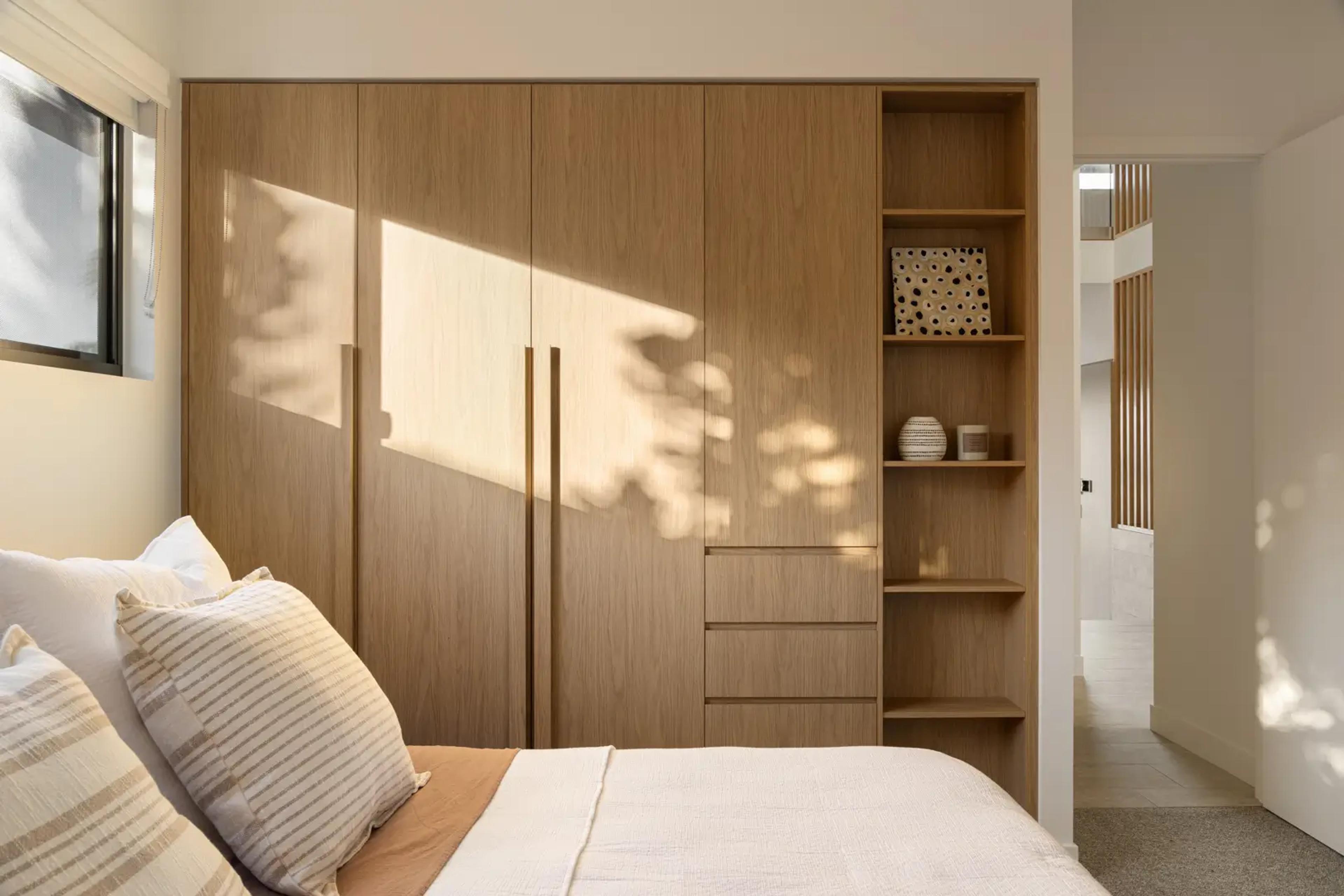 Bedroom with timber wardrobe and shelving niches