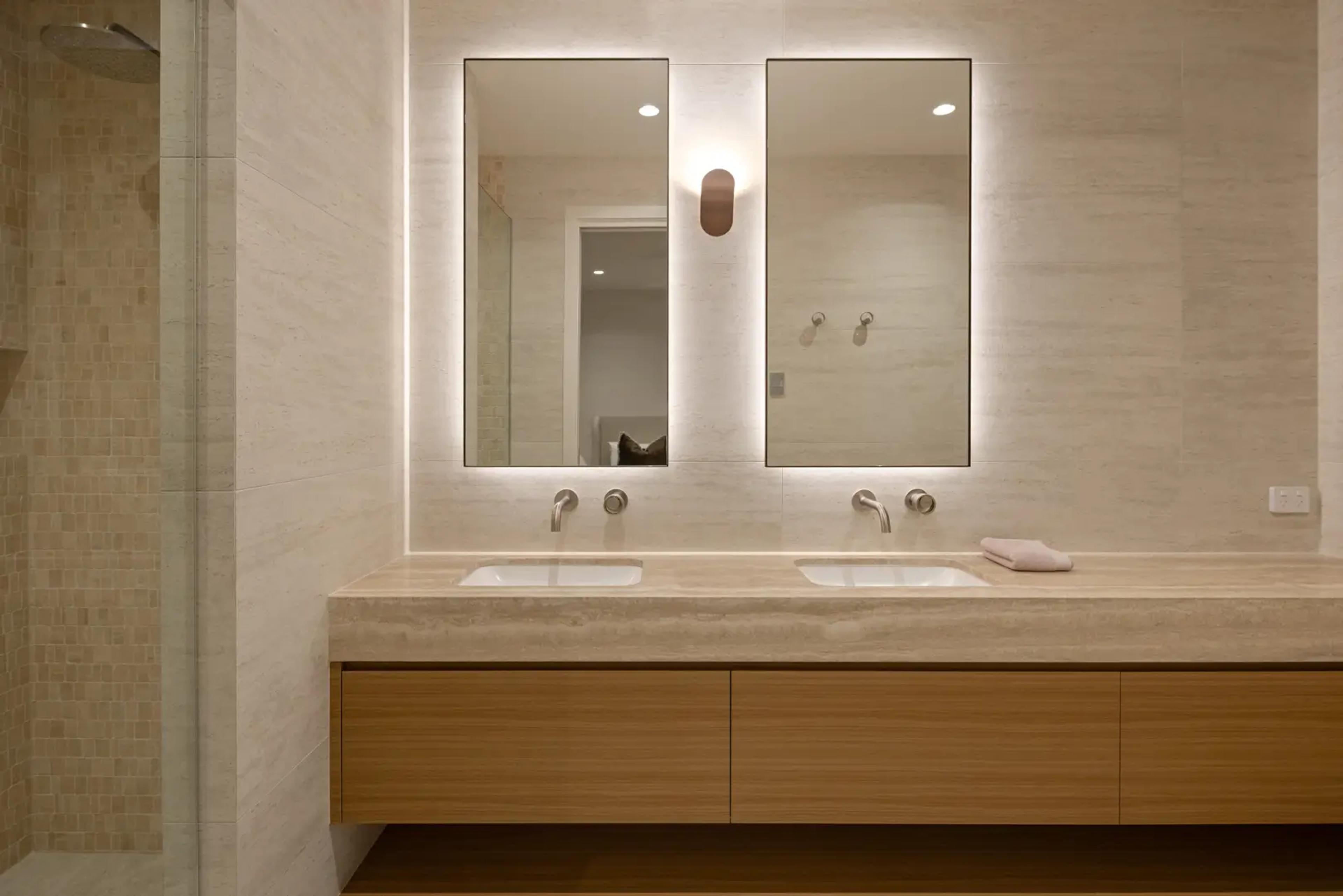 Bathroom with stone vanity, twin mirrors and shower