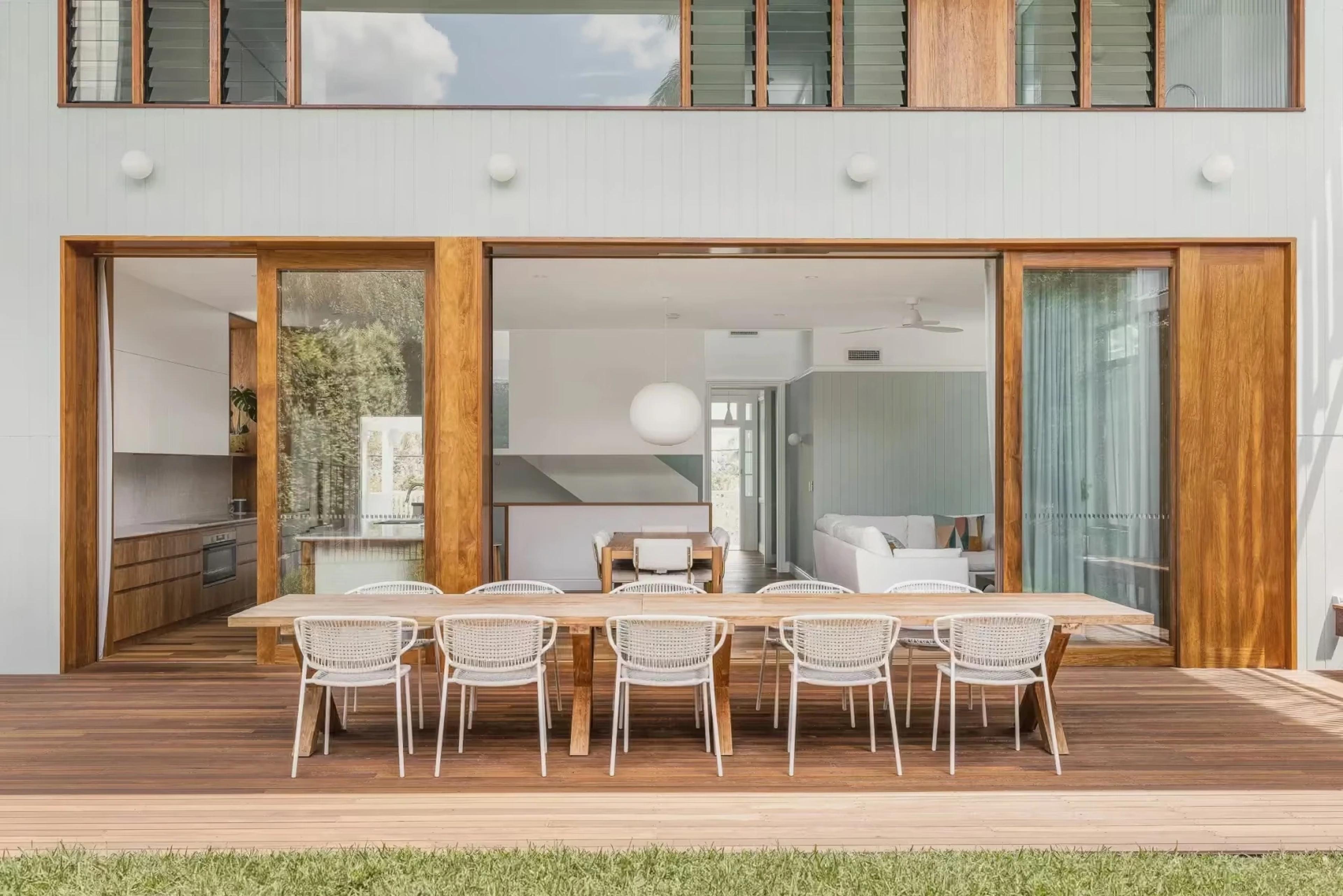 Covered rear deck with dining table and timber sliding doors