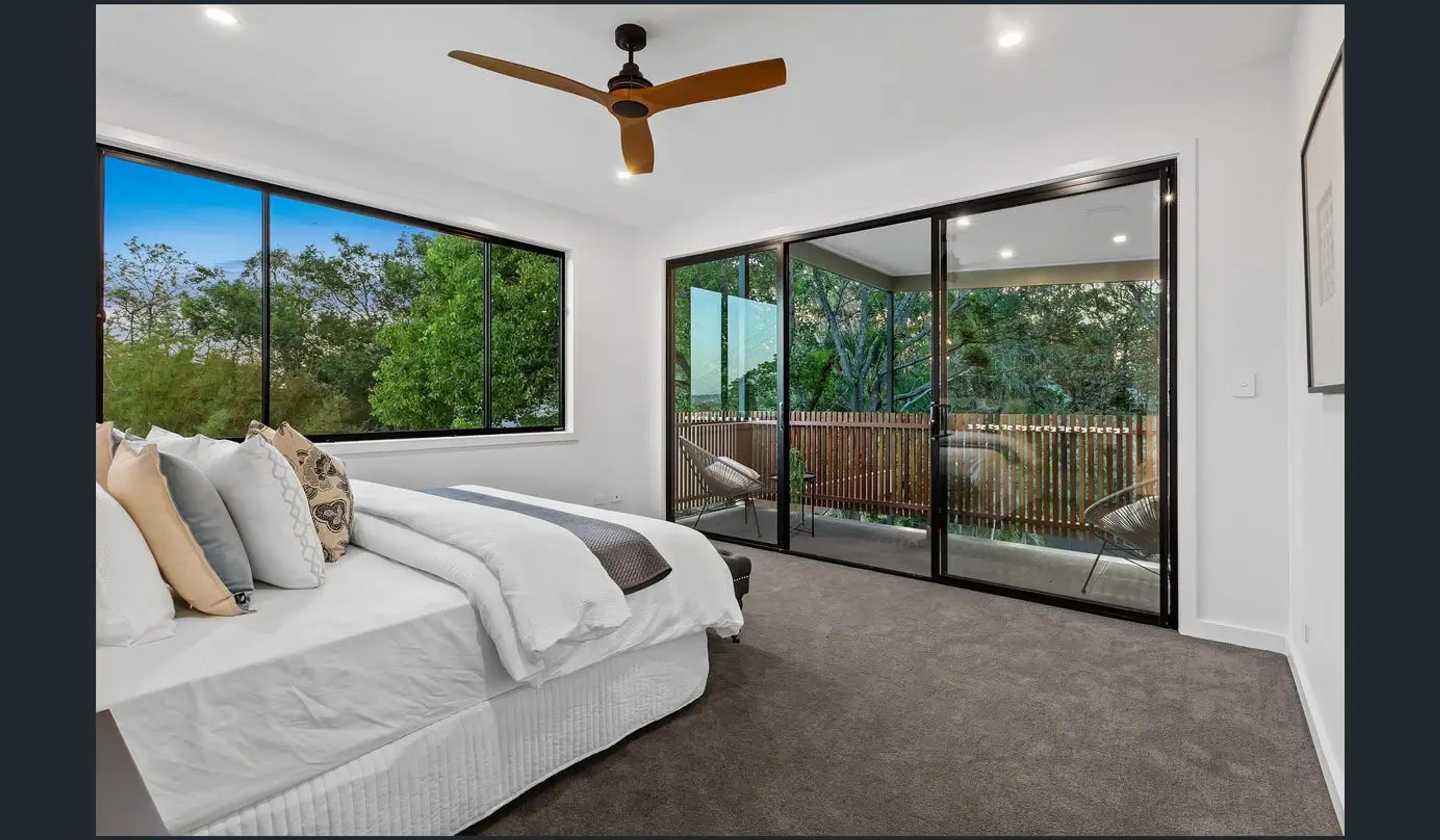Bedroom with sliding doors opening to timber screened balcony