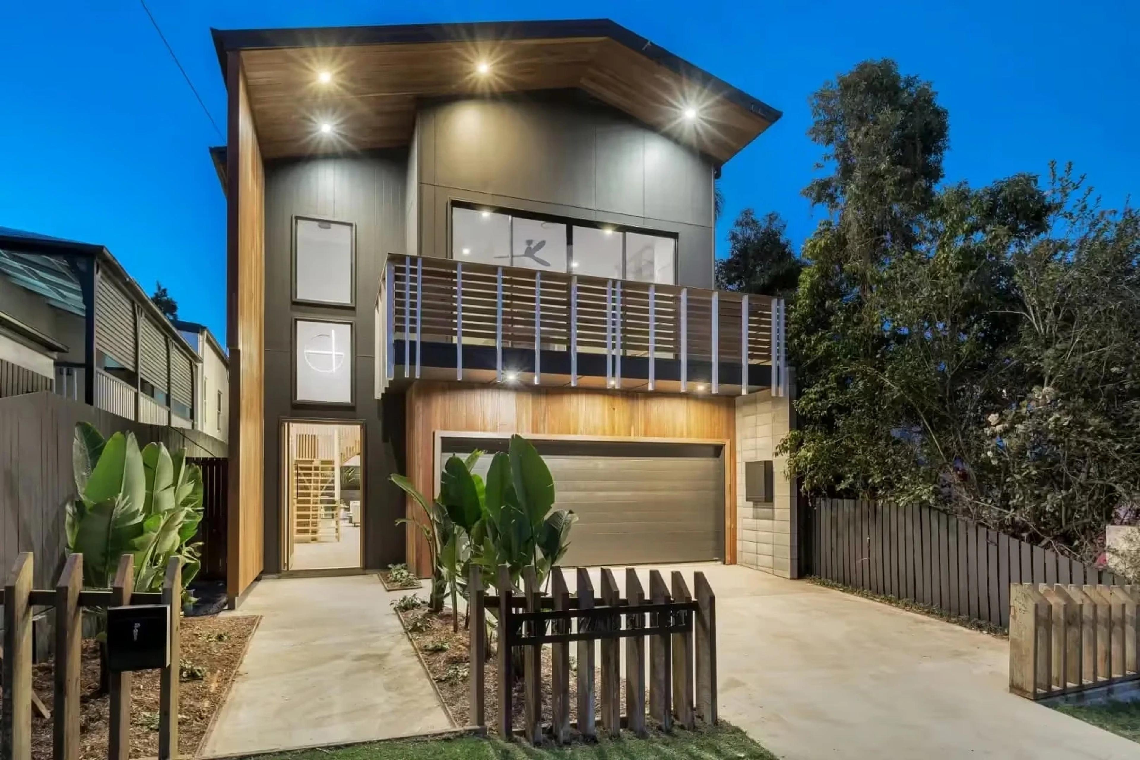 Modern two storey home facade at dusk with double garage