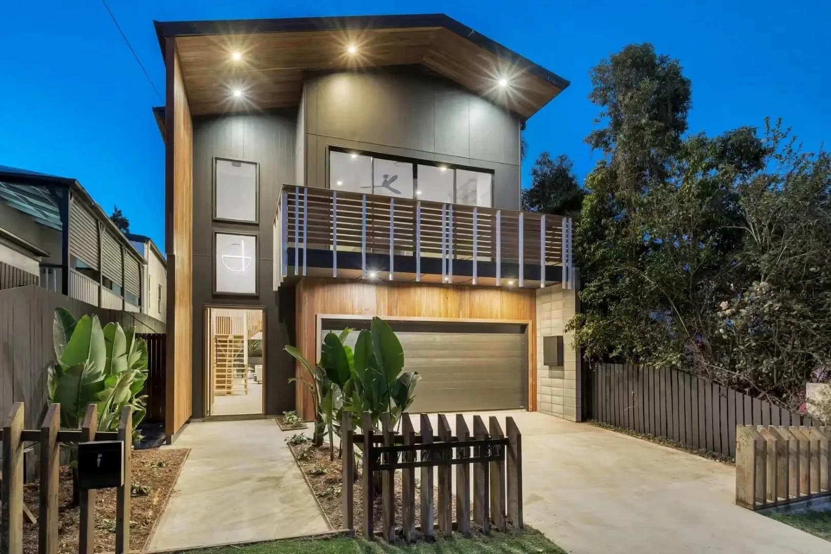 Modern two storey home facade at dusk with double garage