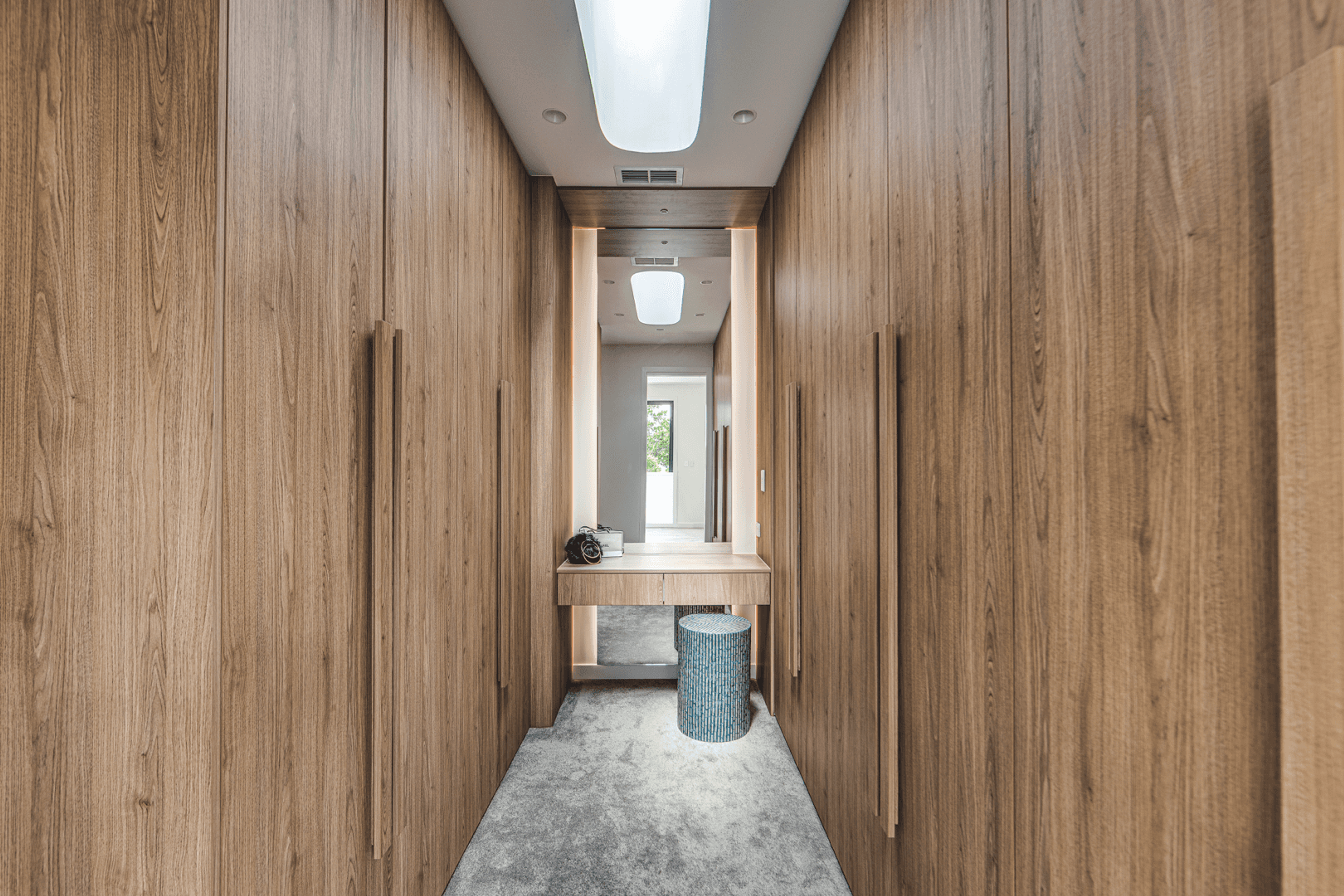 Walk in wardrobe with timber joinery and central bench