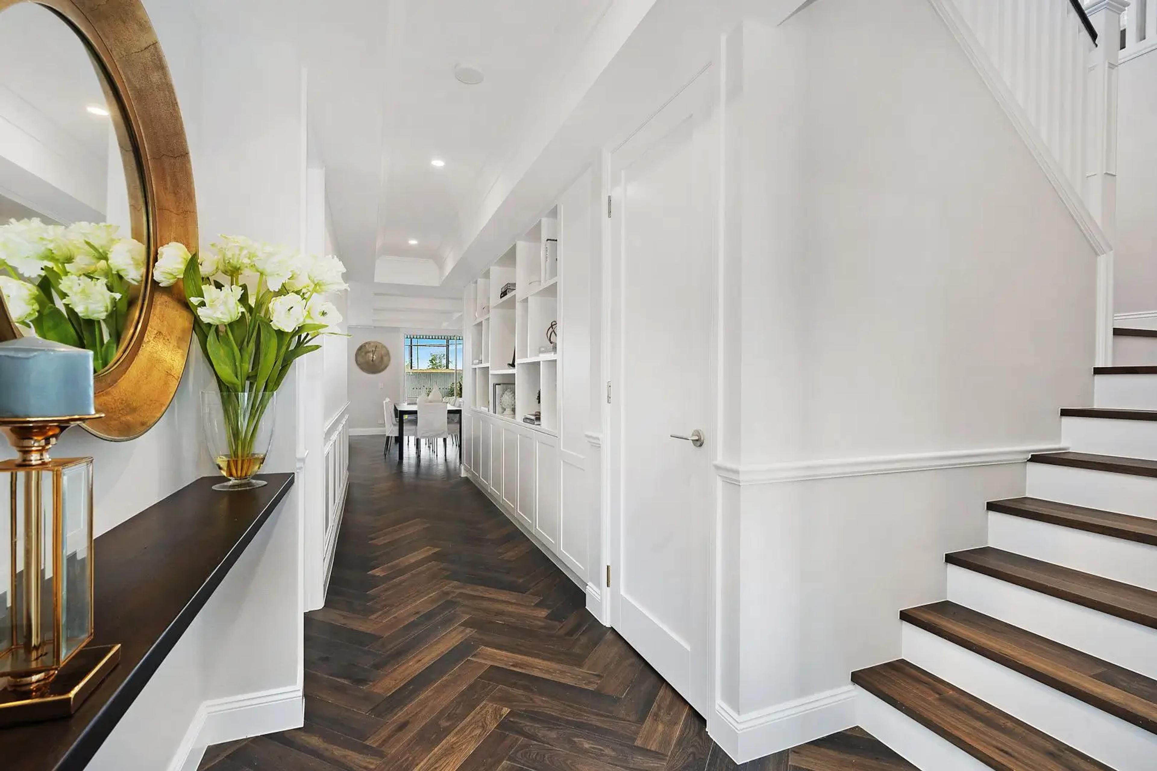 Entry hallway with herringbone timber floor and staircase