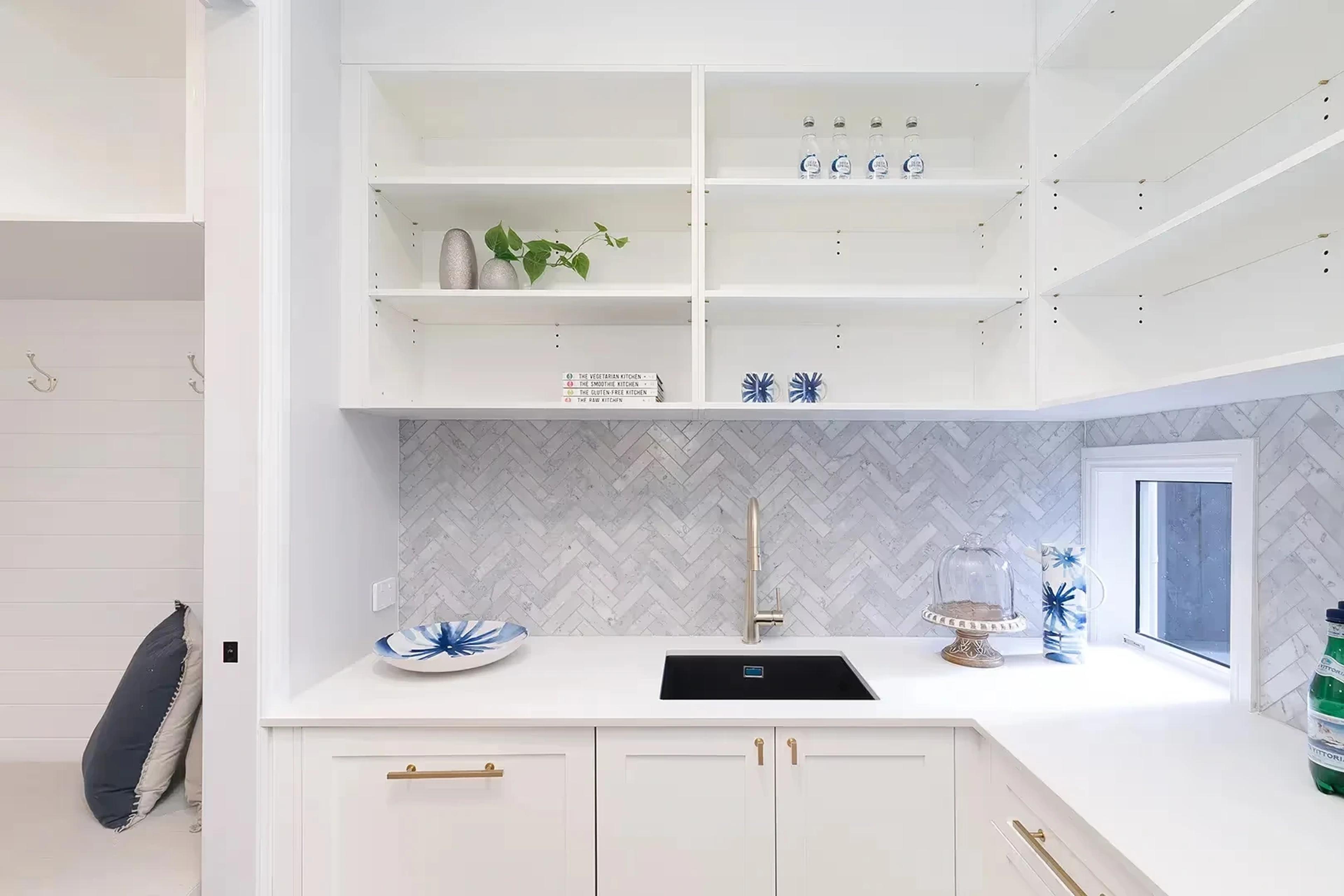 Butler pantry with white cabinetry and herringbone splashback
