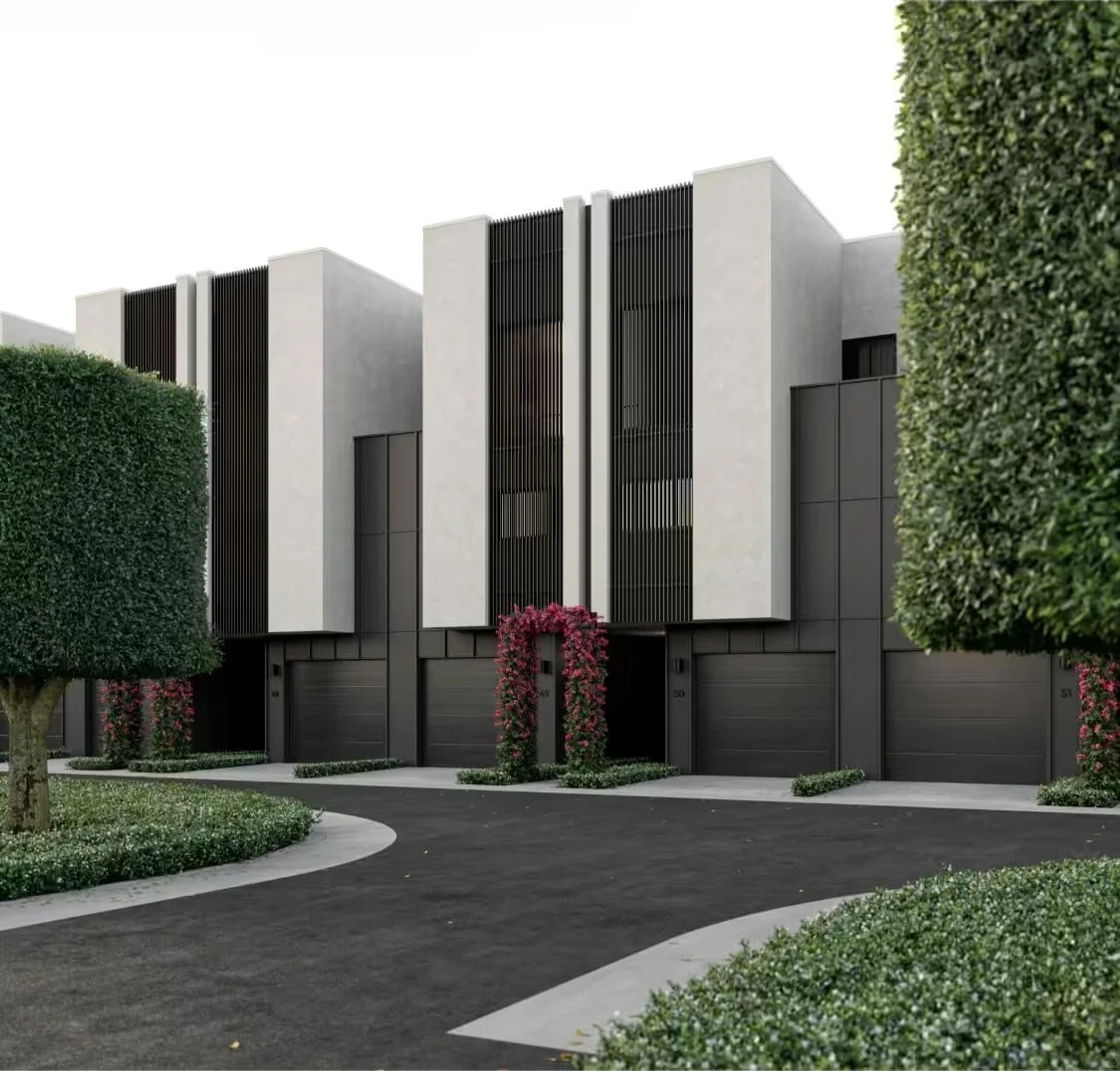 Row of townhouse fronts with garages and landscaped driveway
