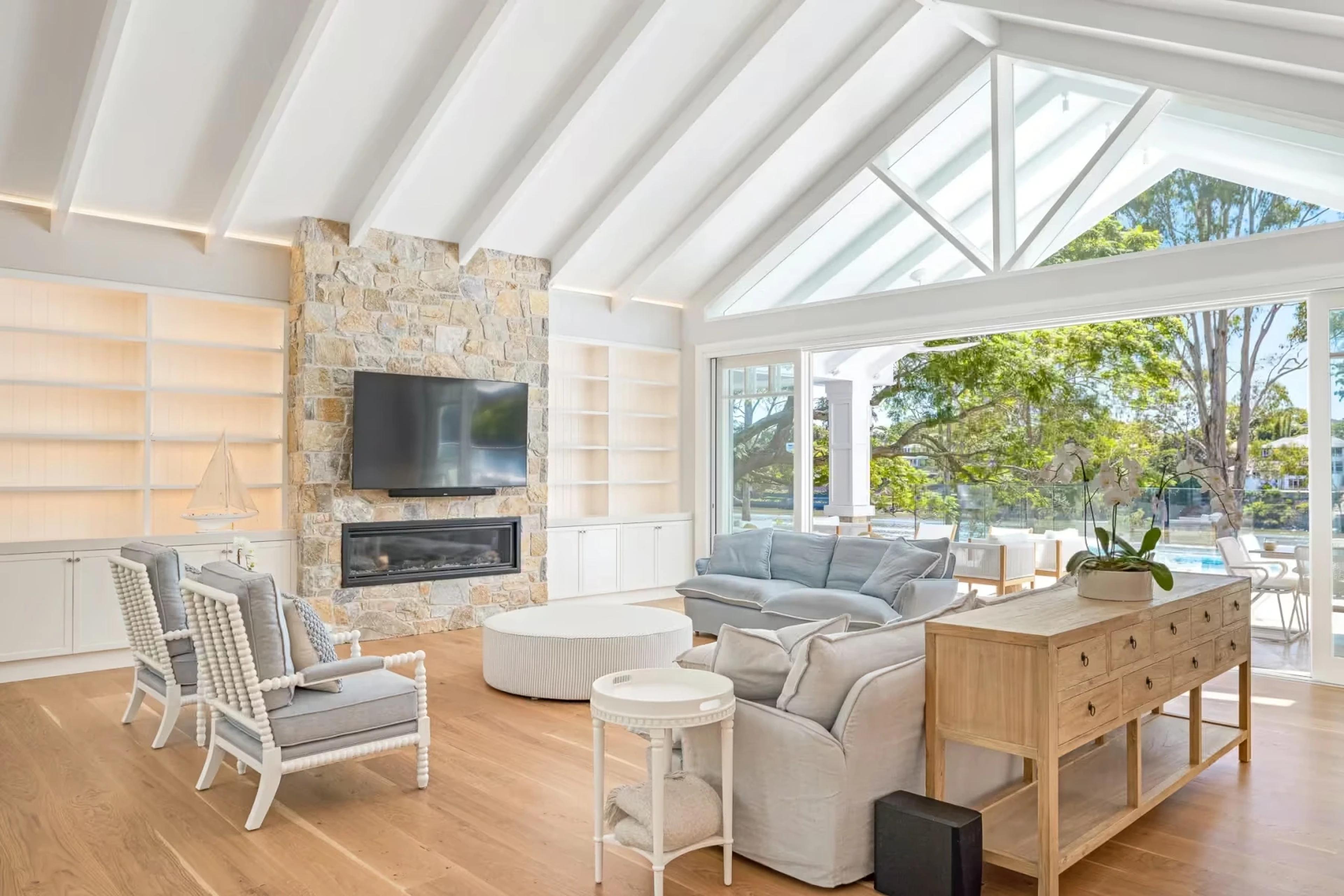 Living room with stone fireplace and vaulted ceiling