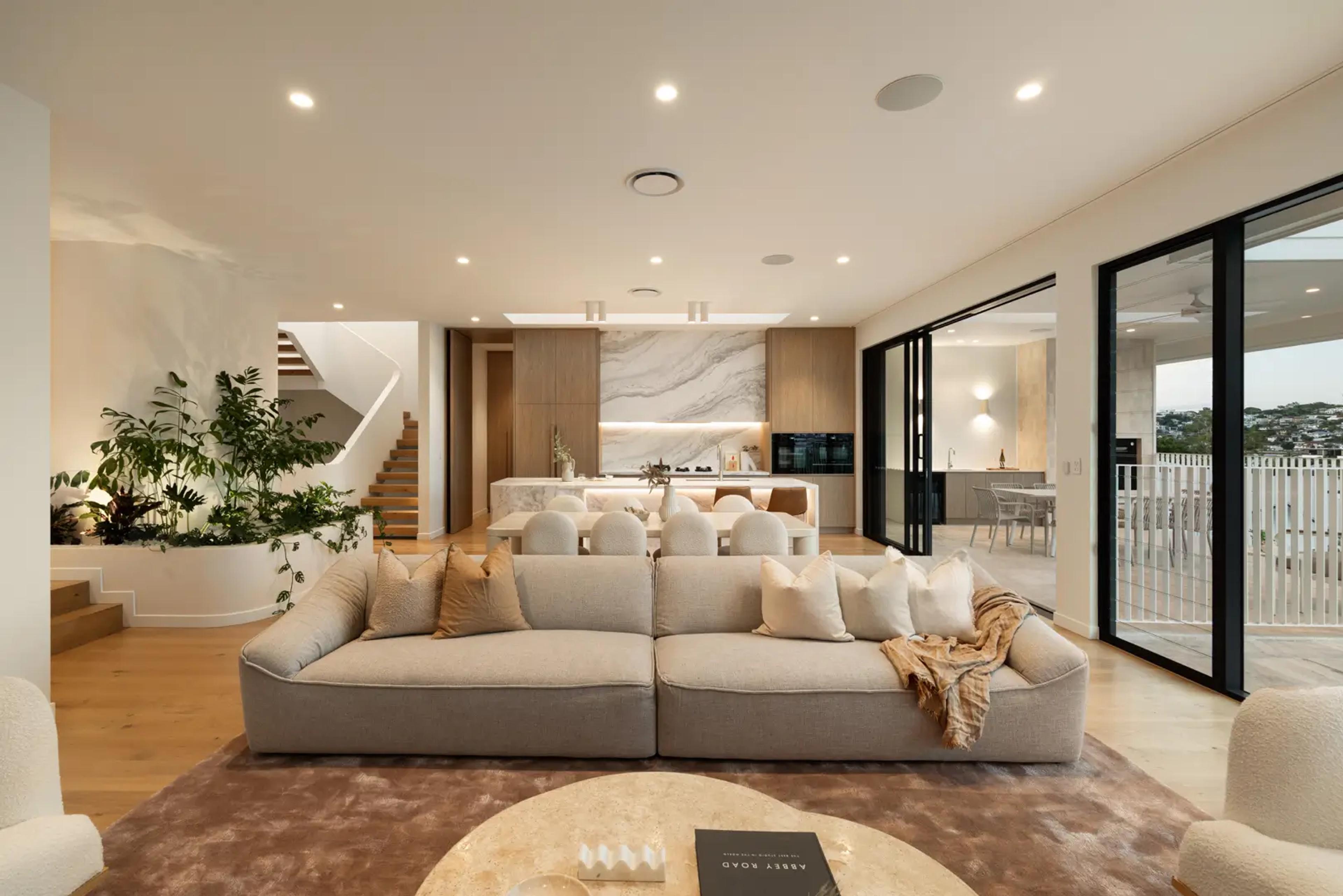 Living room with sofa opening to kitchen and terrace