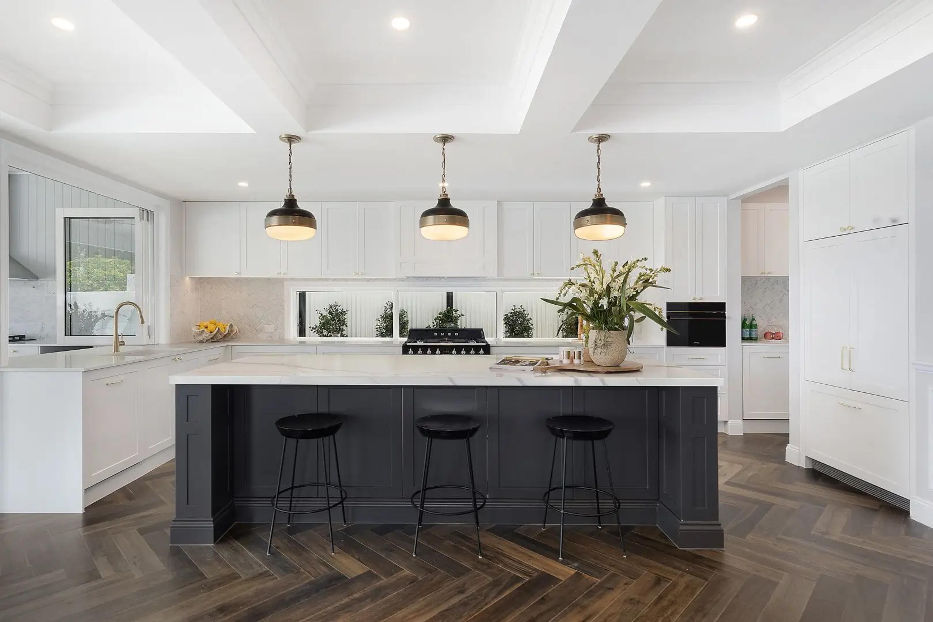 Kitchen with marble island, pendant lights and black stools