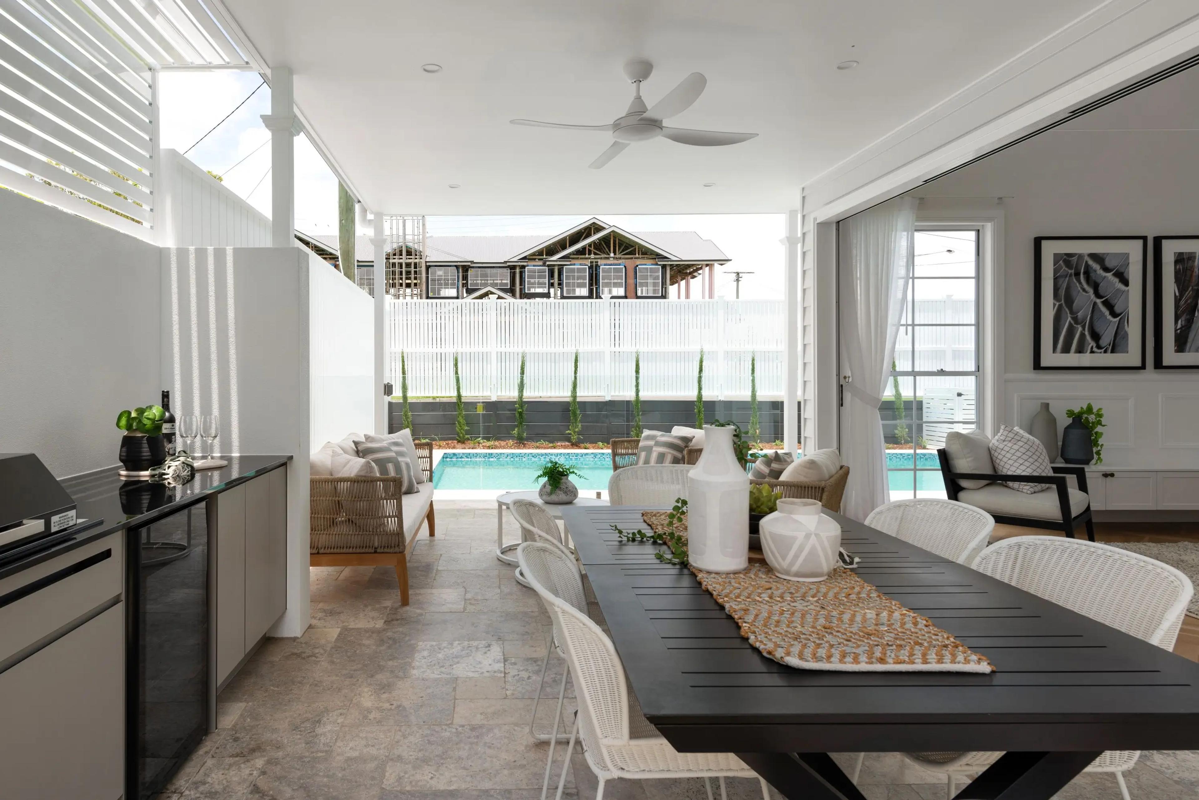 Covered alfresco dining area overlooking pool and rear garden