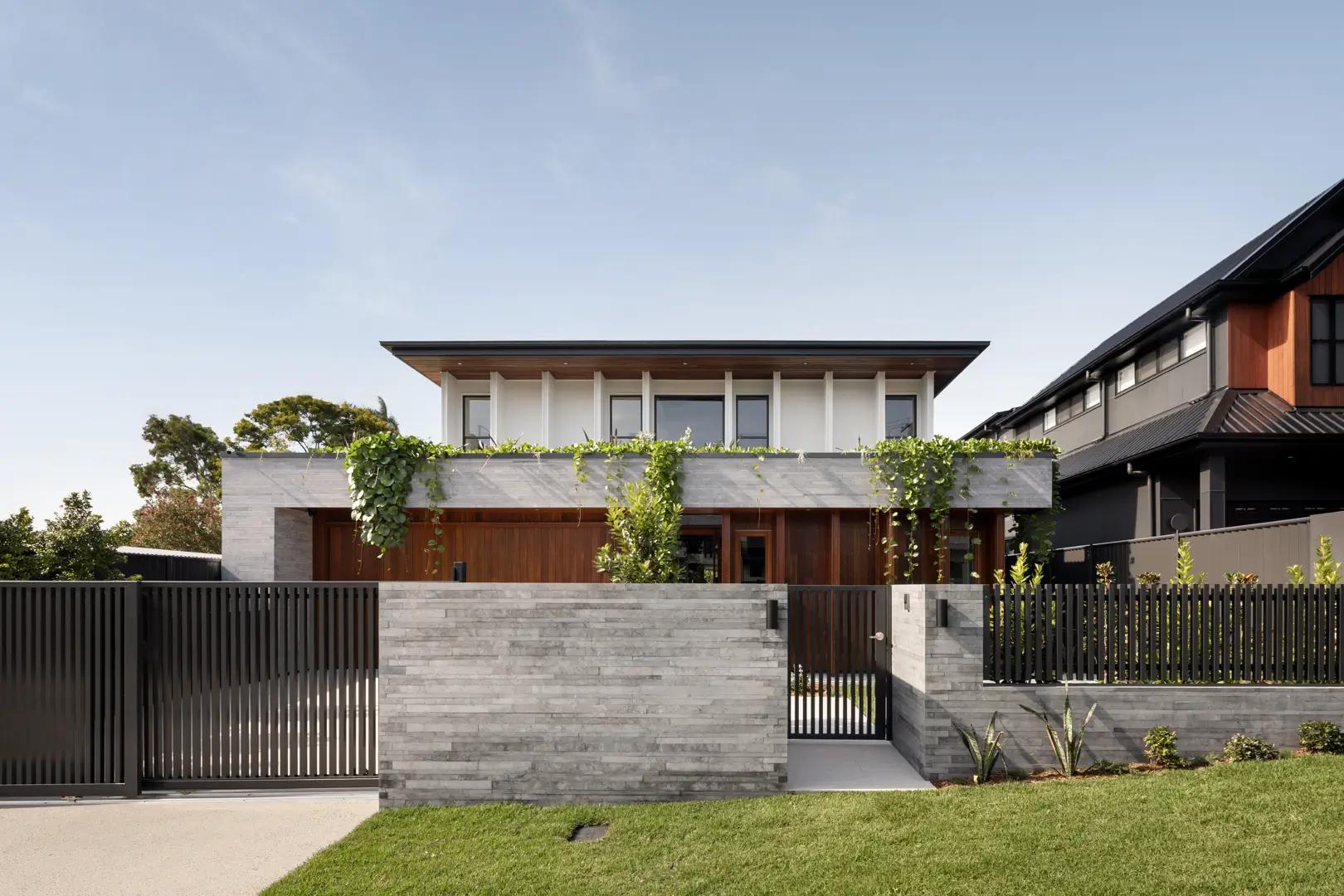 Front facade behind timber gate and stone fence
