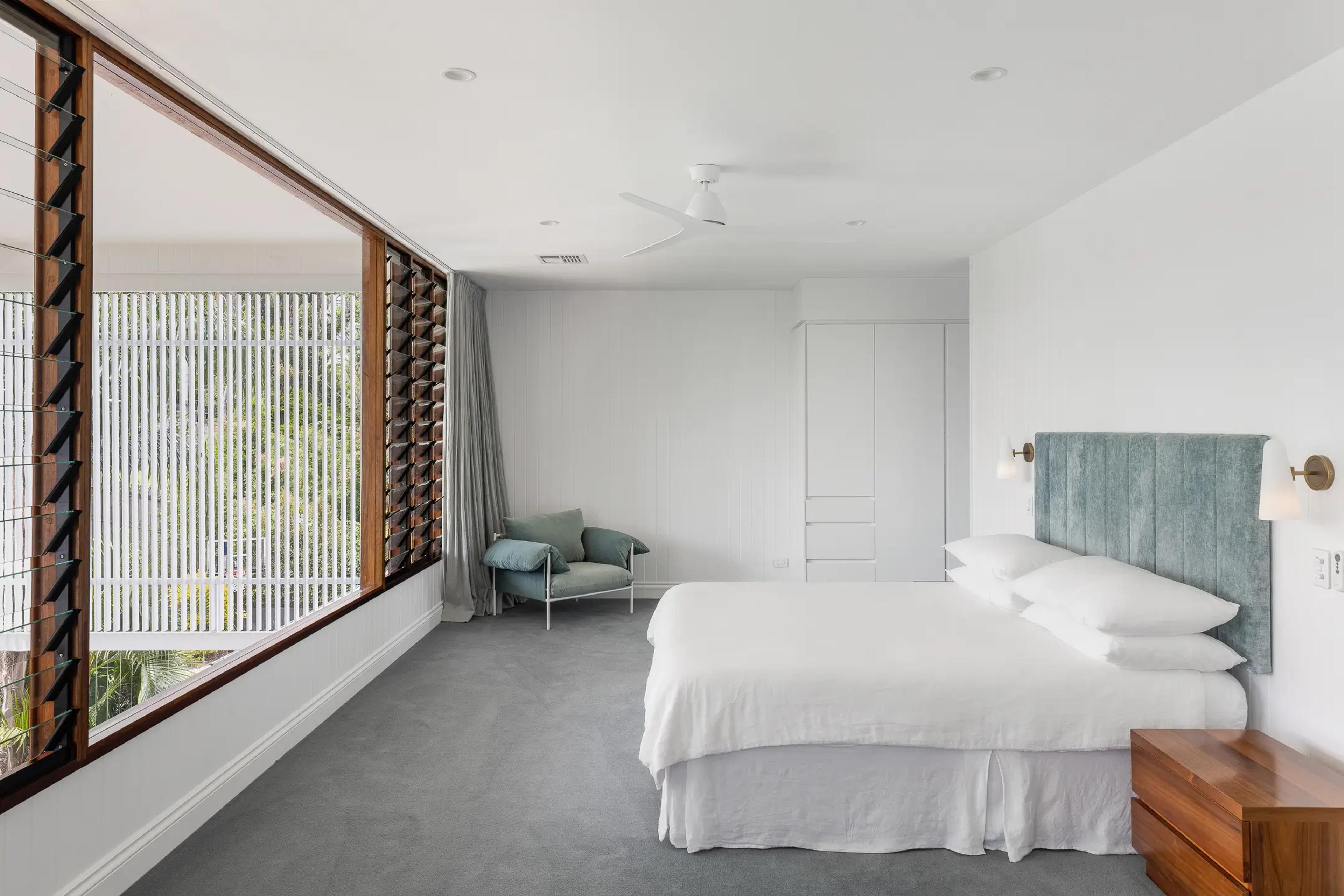 Main bedroom with louvre windows and upholstered bedhead