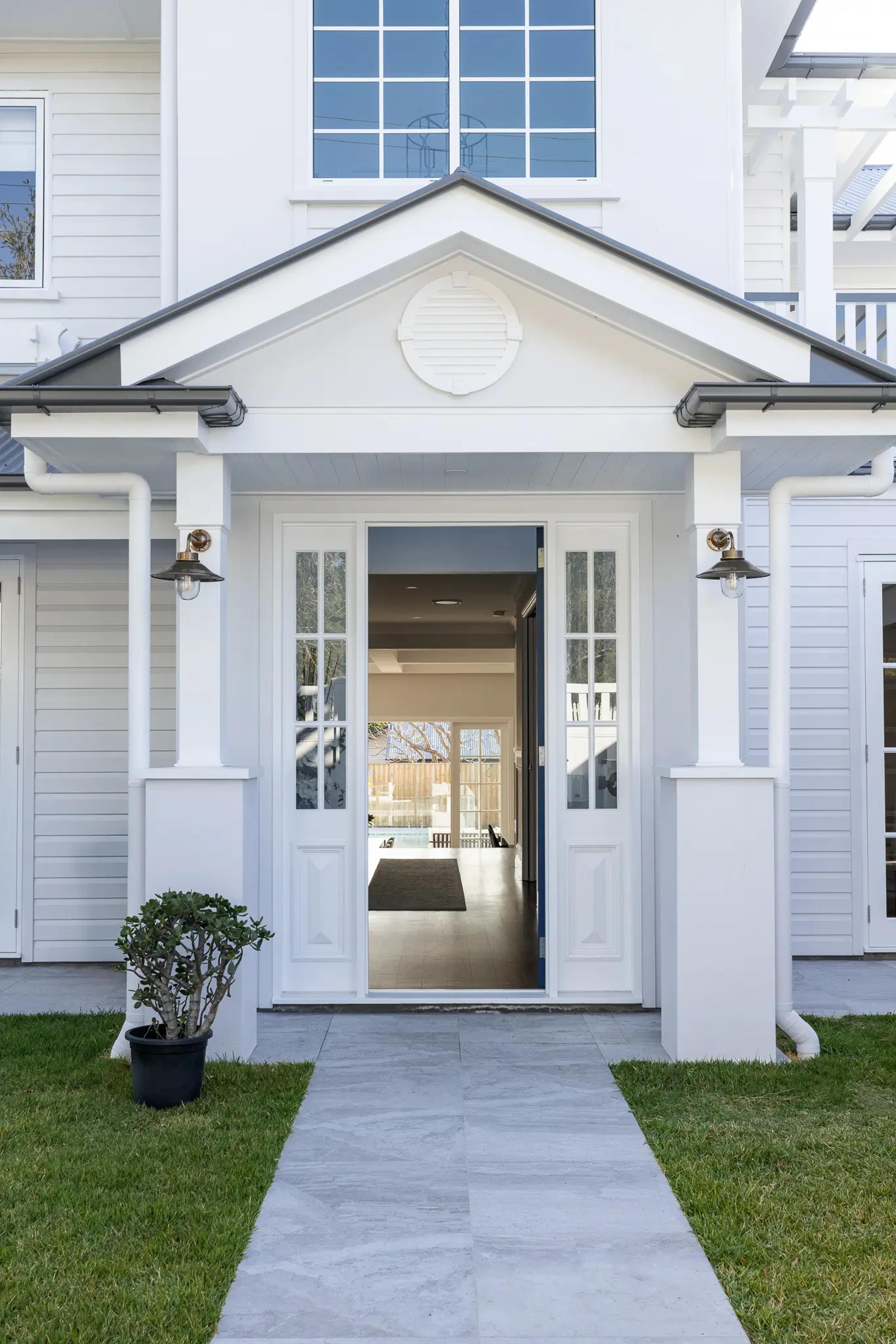 Front entry portico with white columns and glass door