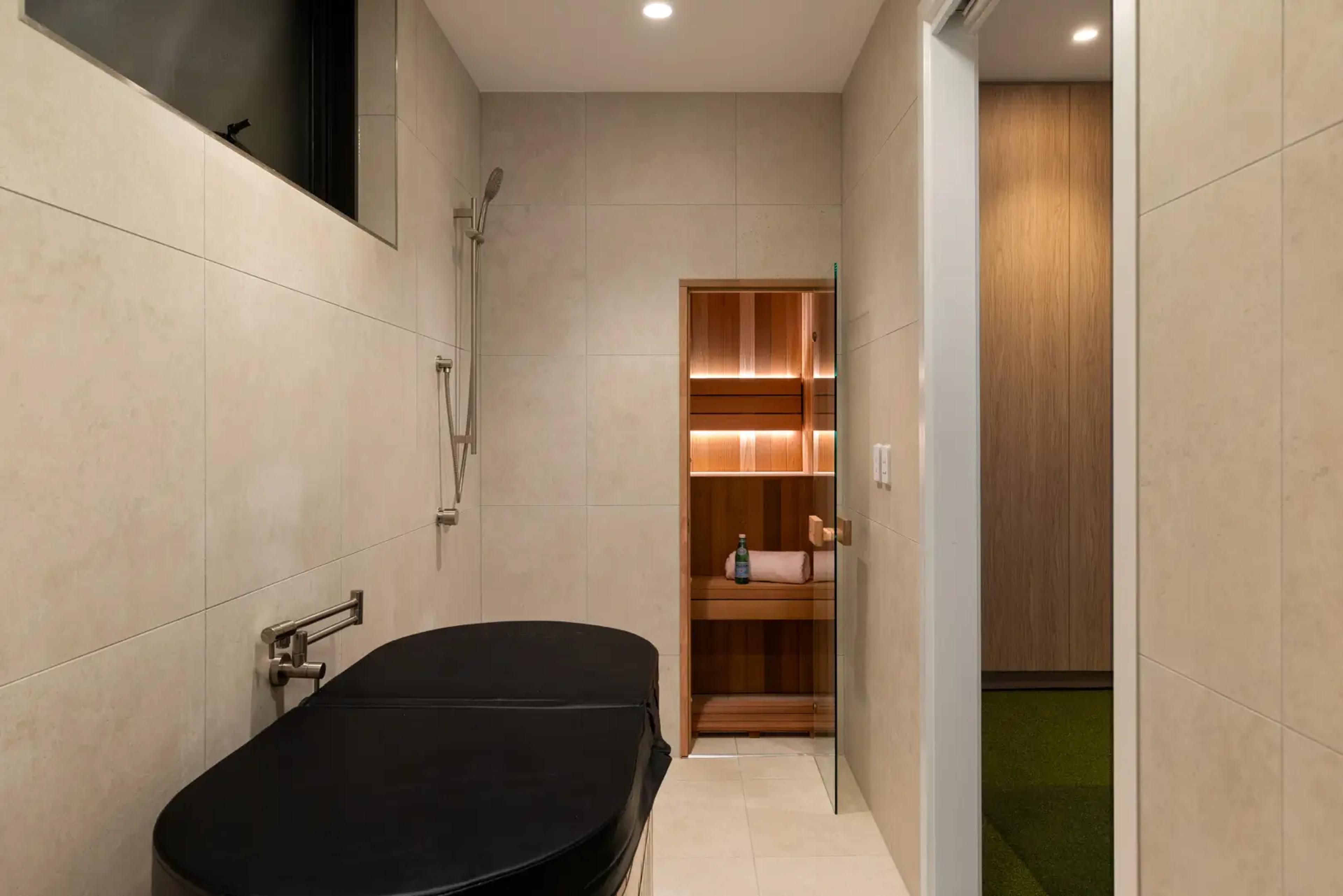 Wellness room with massage table and timber sauna