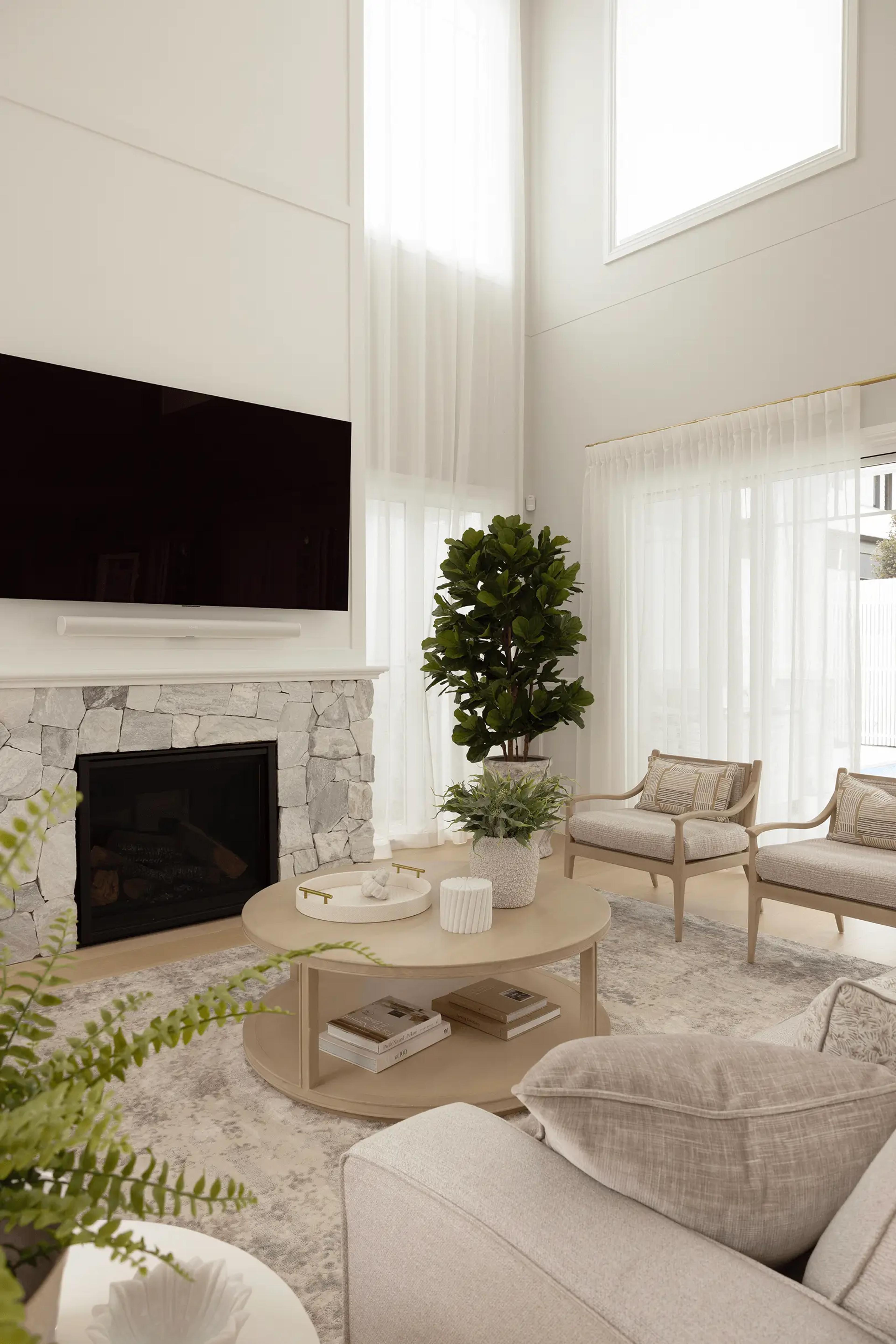 Double-height living room with fireplace and armchairs