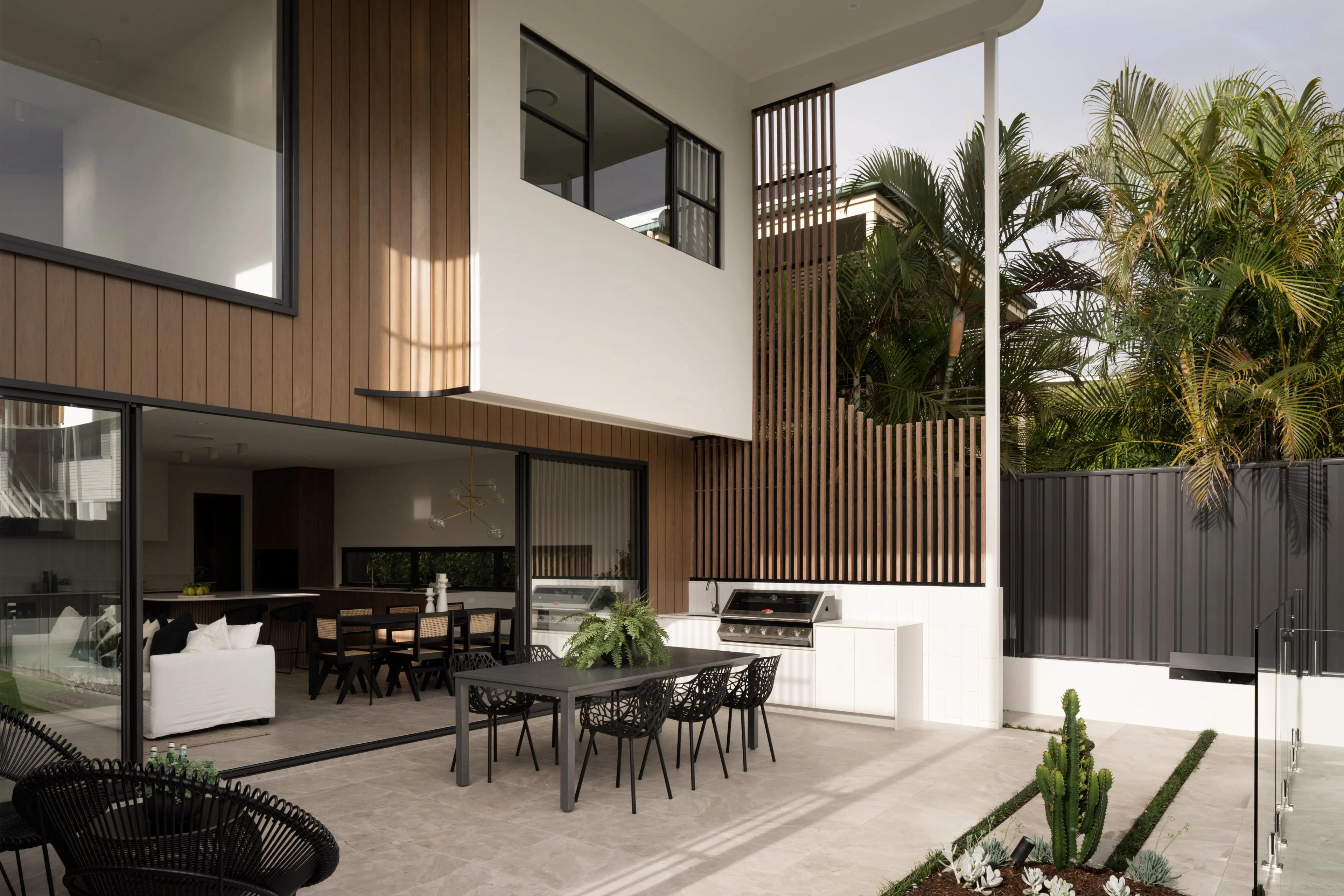 Covered outdoor dining and kitchen with tropical planting