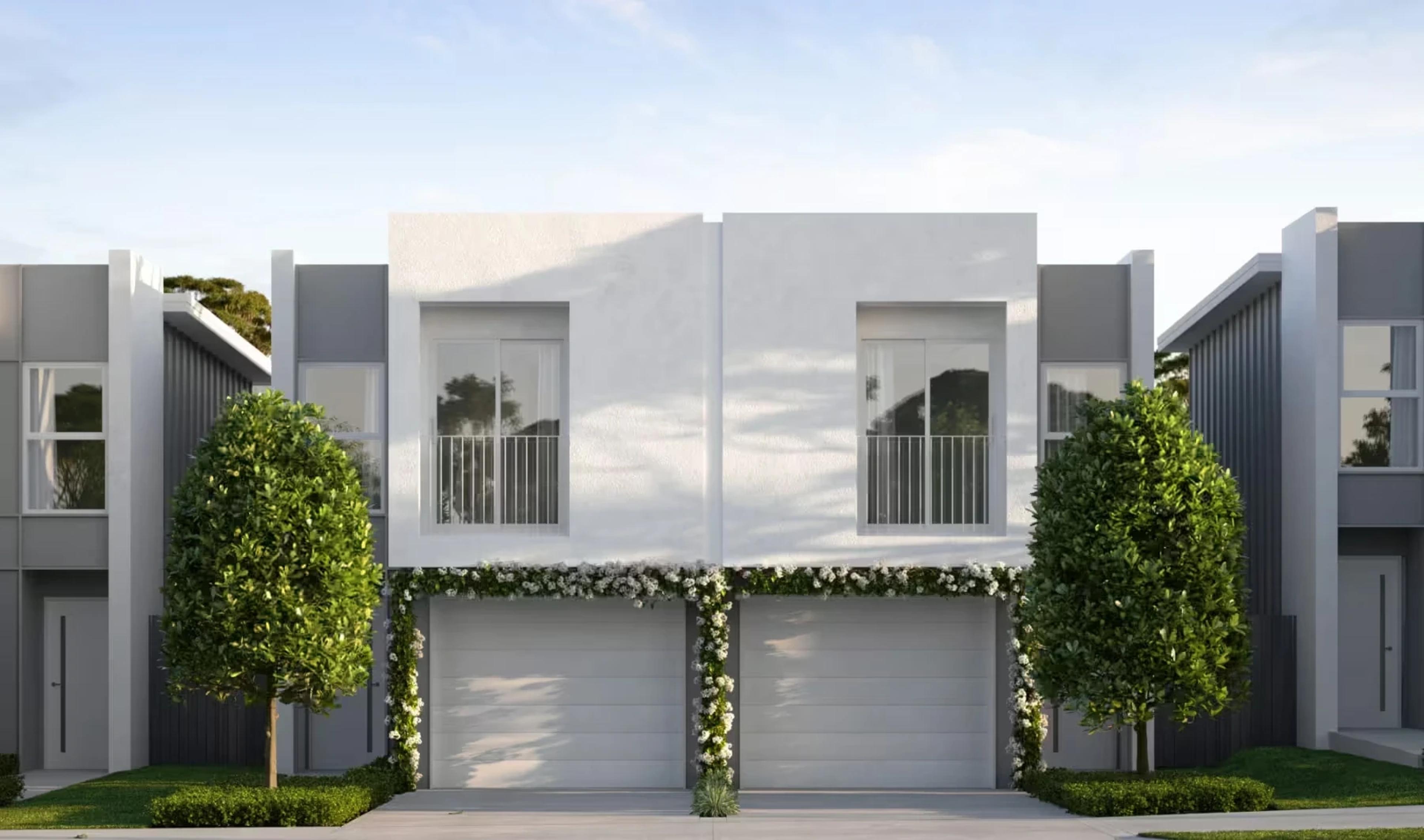 Front elevation of white rendered townhouses with twin garages