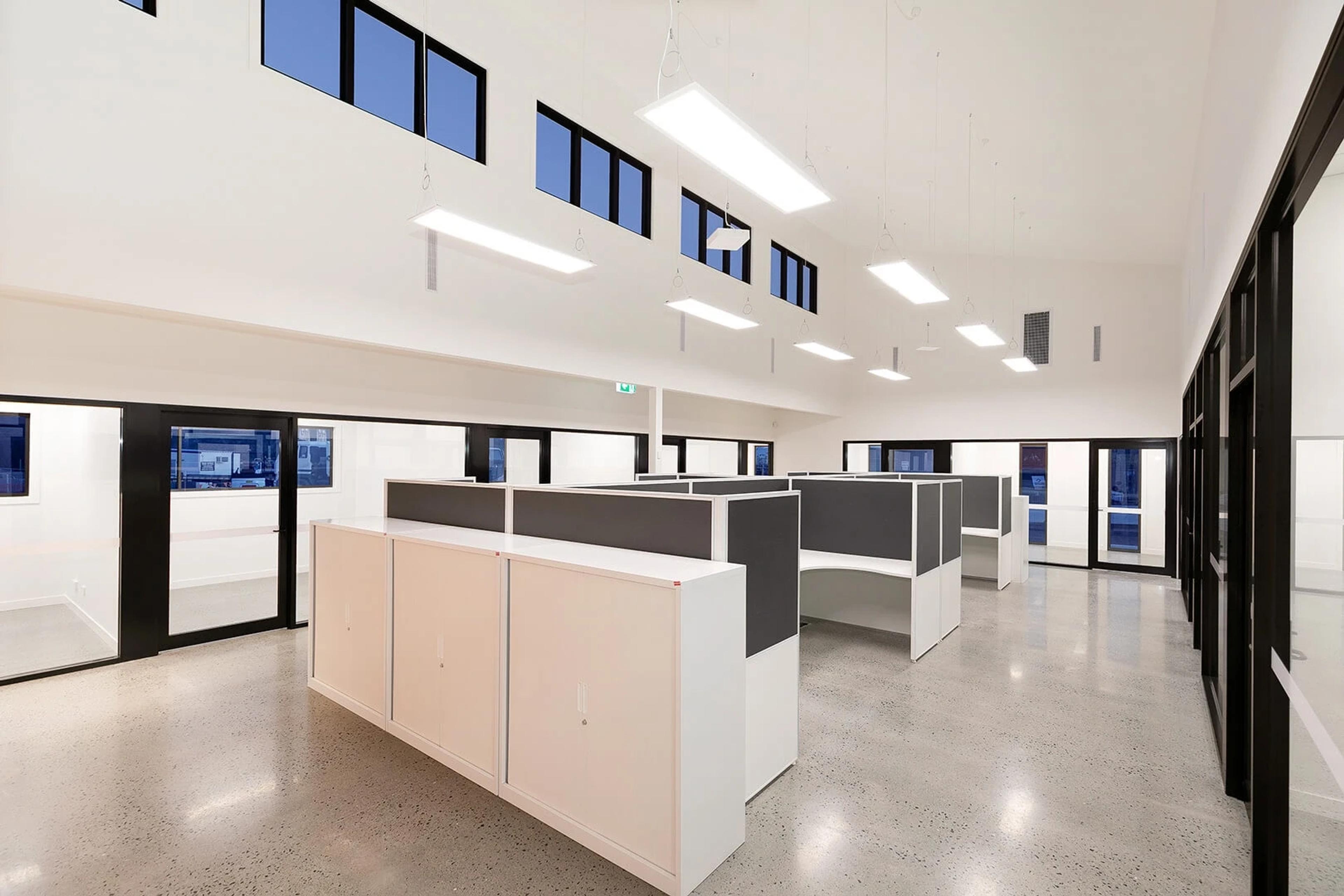 Open plan workspace with high ceilings and pendant lighting