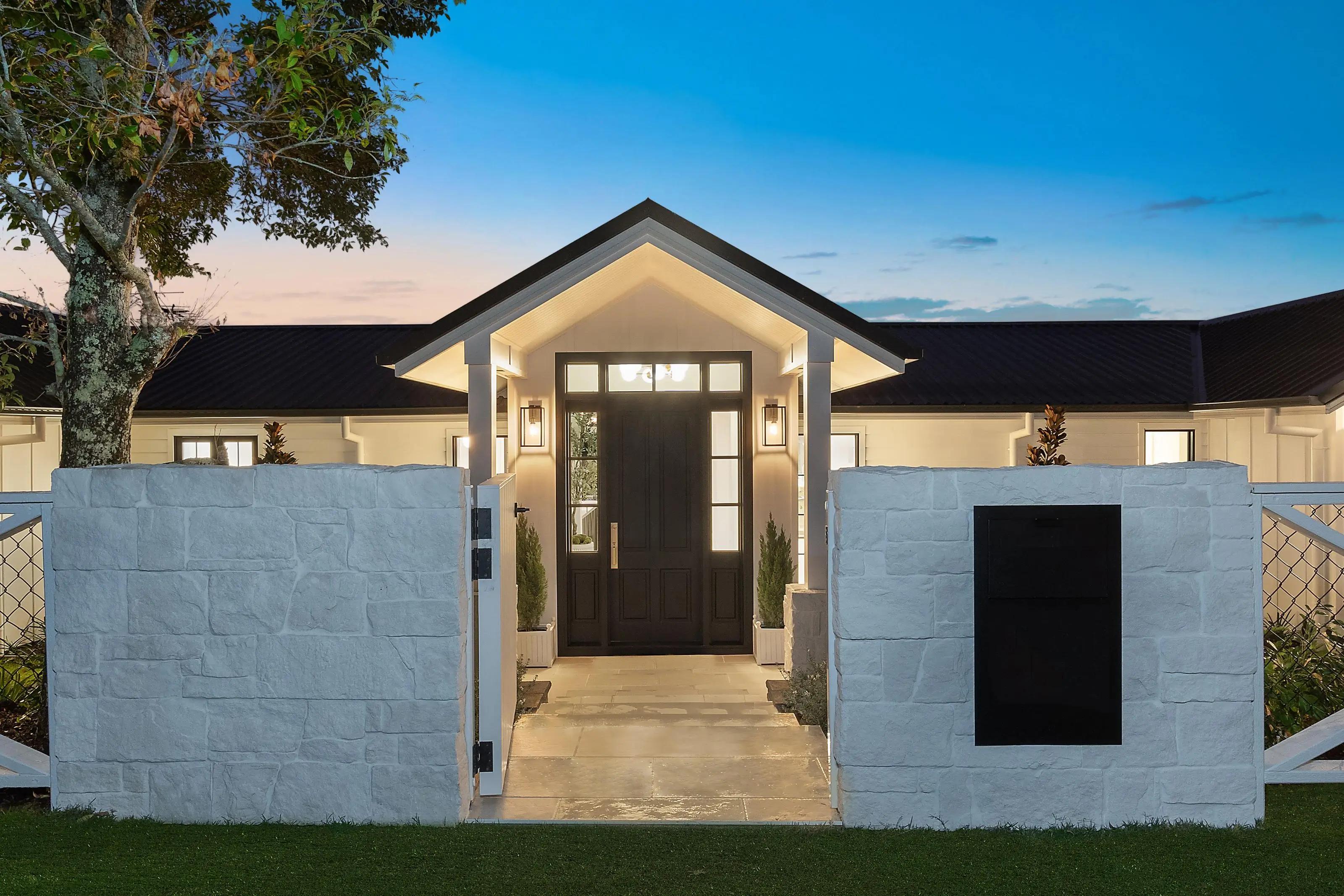 Modern luxury home facade featuring warm entryway lighting ideas by Invilla Architecture