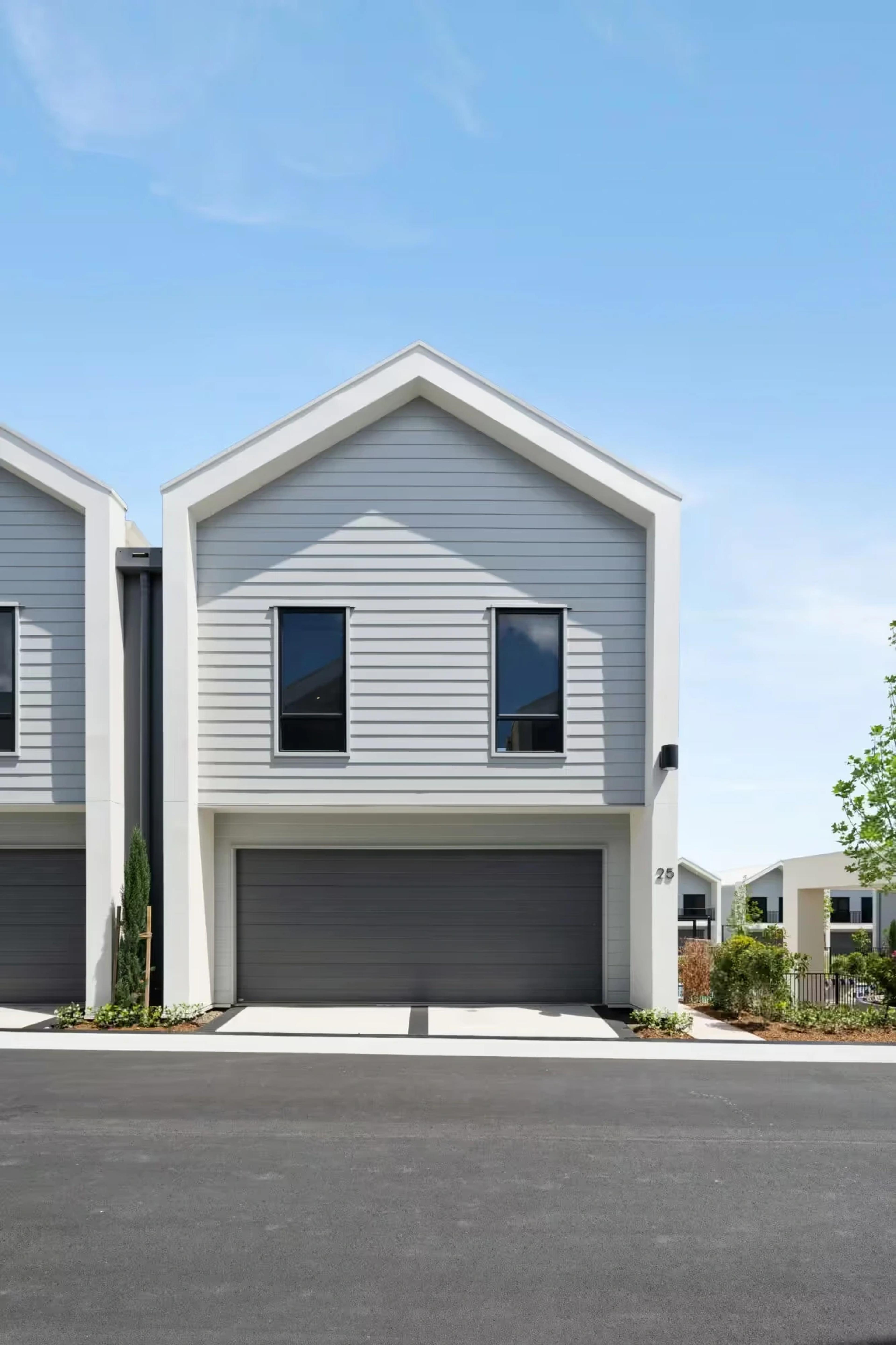 Front elevation of a two storey gabled townhouse with garage
