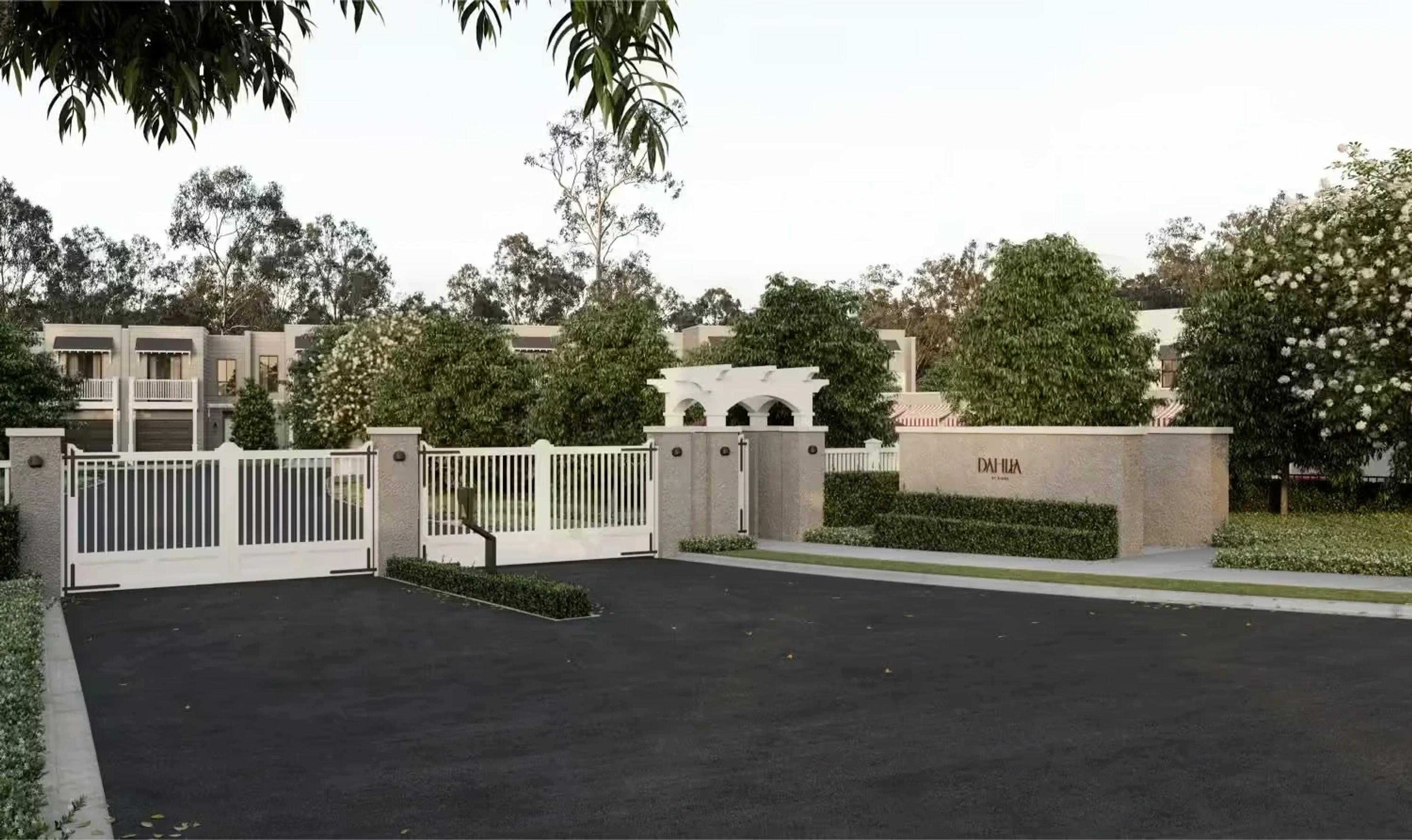 Gated estate entrance with white fencing and signage wall